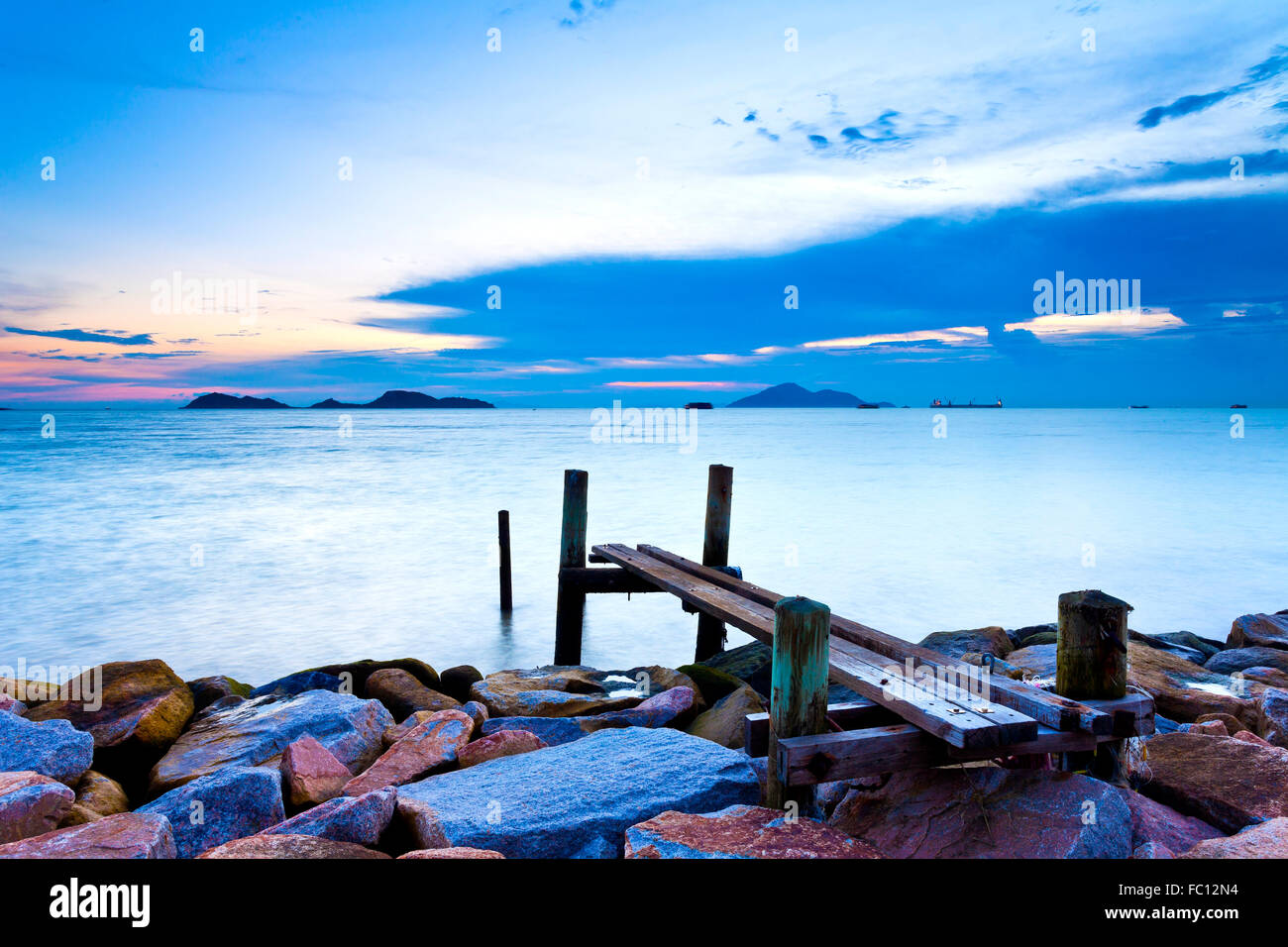 Jetty on sea at sunset Stock Photo - Alamy