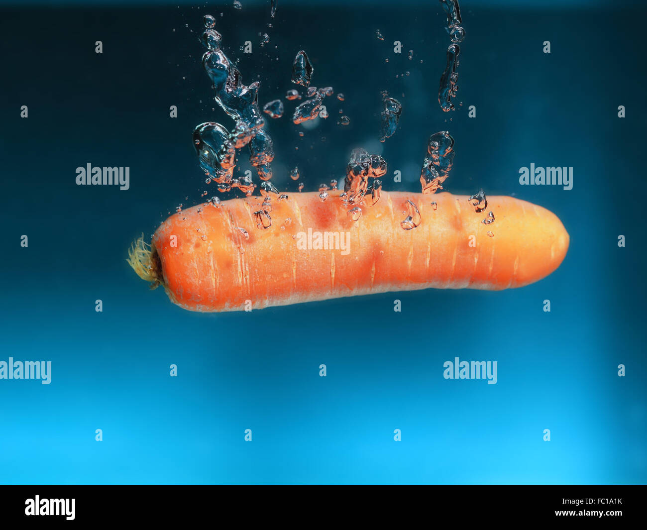 Carrot in the water splash over blue Stock Photo Alamy