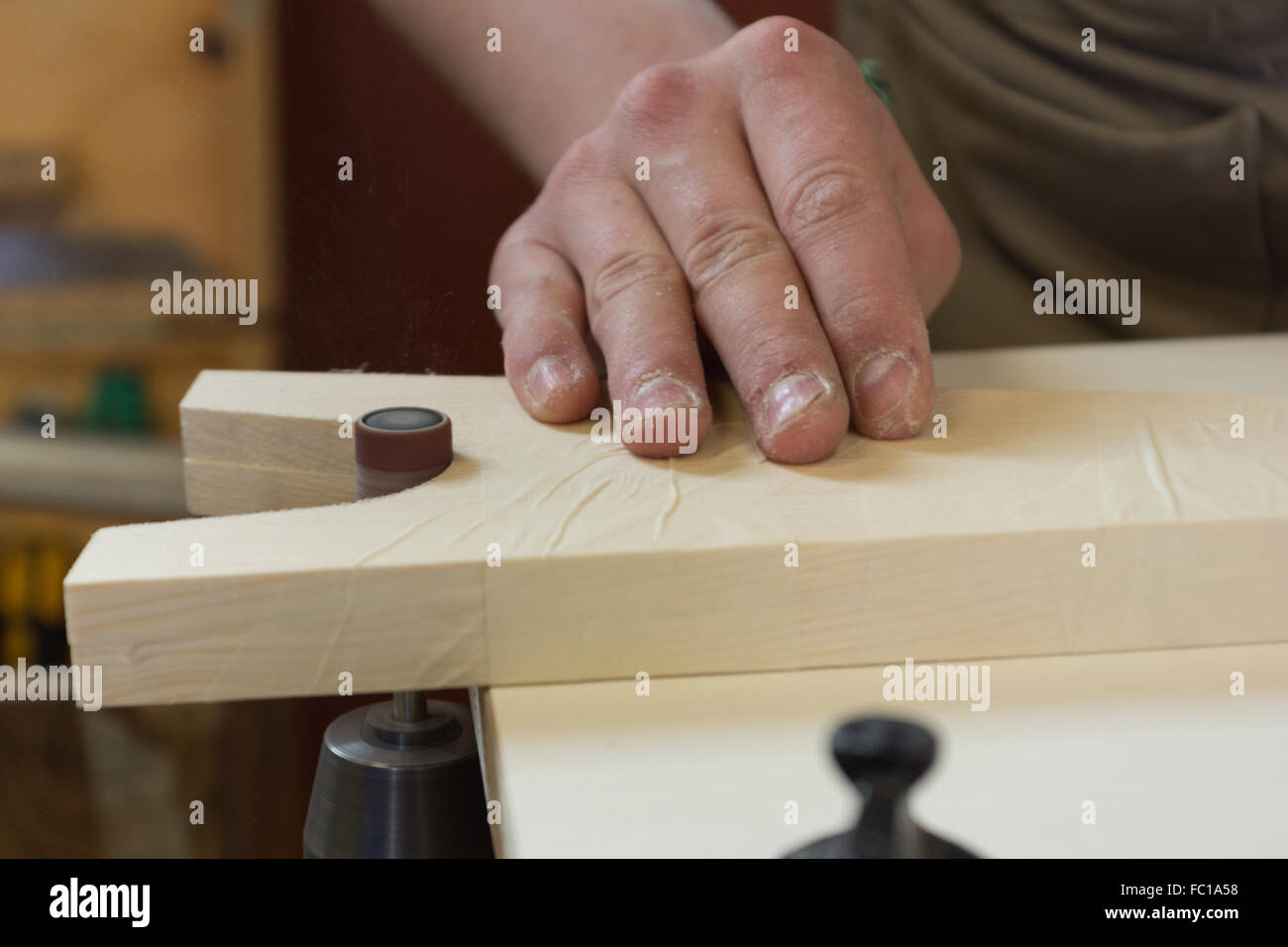 Carpenters grinds wood with machine Stock Photo