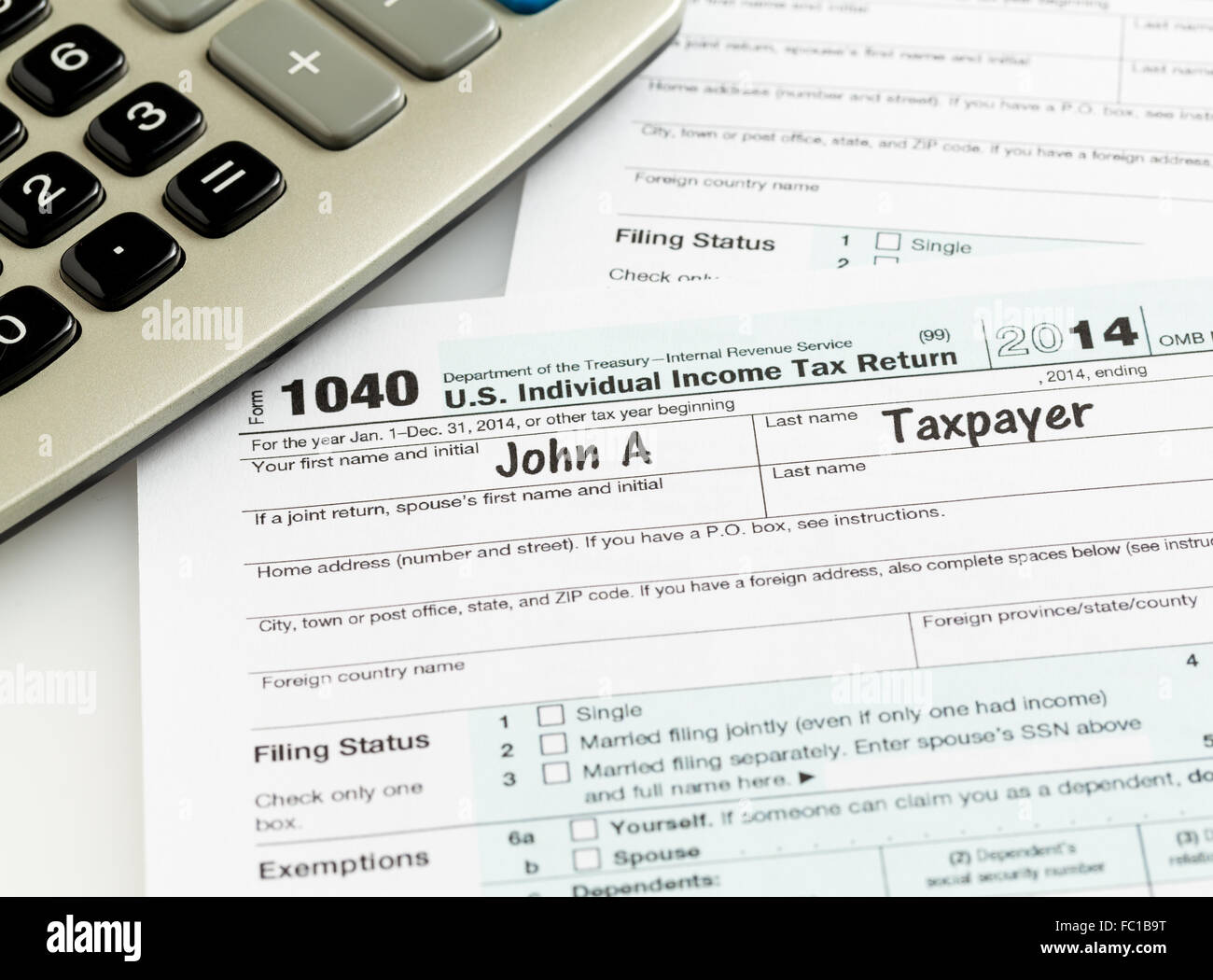 Pen and calculator on 2014 form 1040 Stock Photo