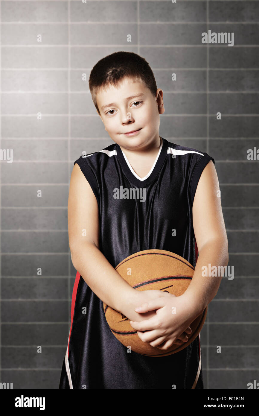 Contented kid holding basketball Stock Photo