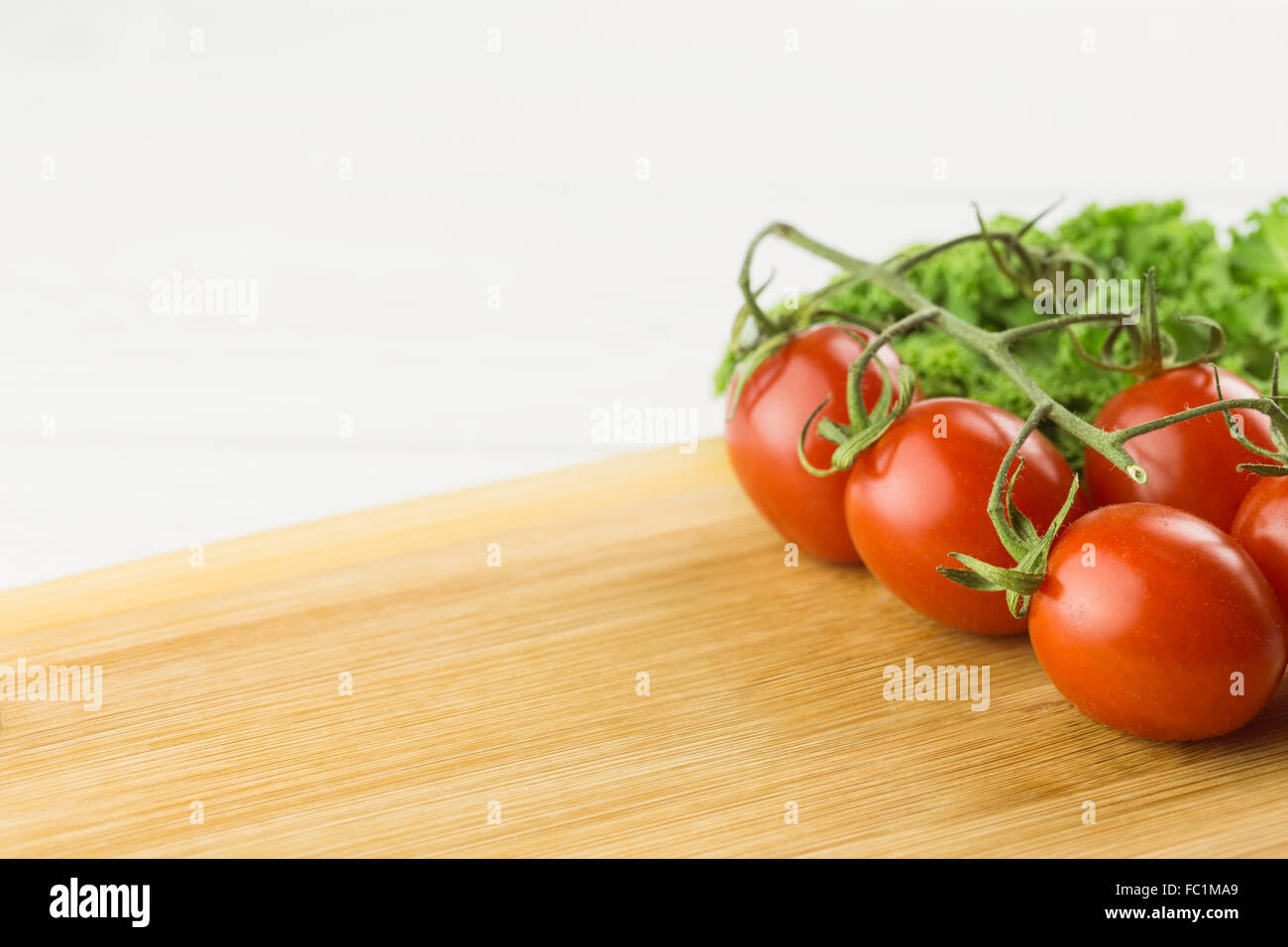 Cherry tomatoes and parsley on chopping board Stock Photo - Alamy