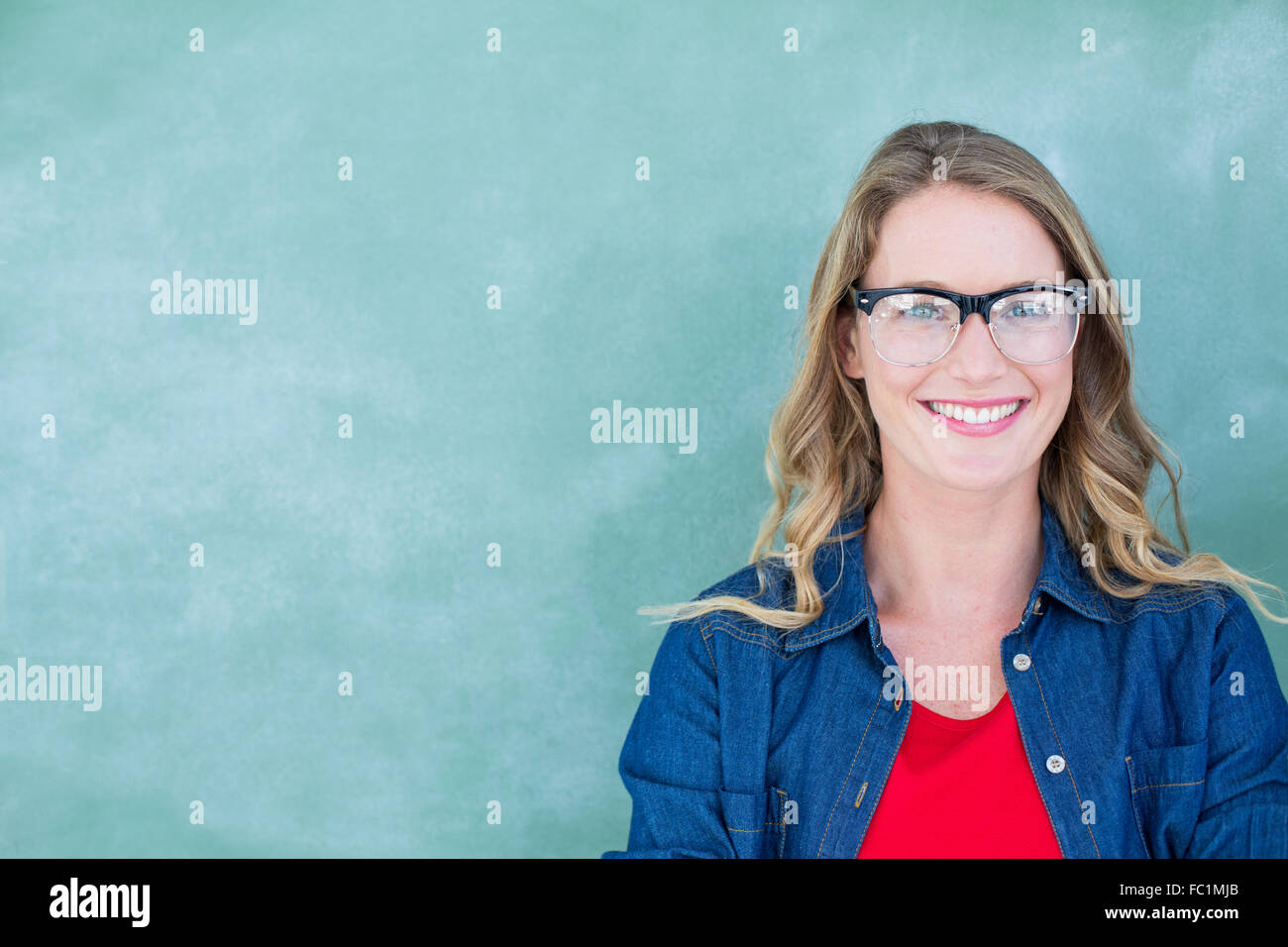 Smiling geeky teacher standing in front of blackboard Stock Photo - Alamy