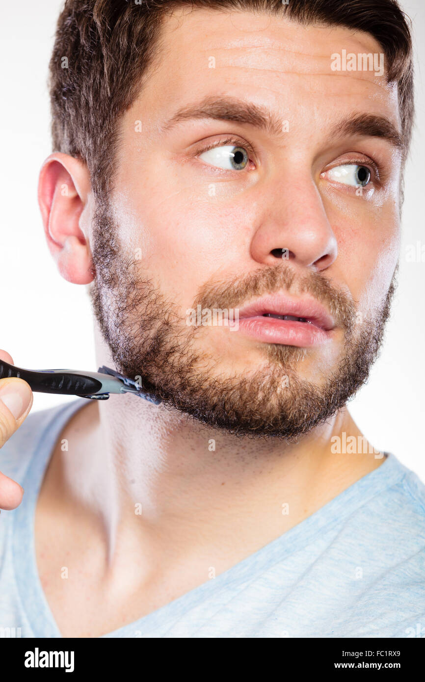 Young man with beard holding razor blade Stock Photo