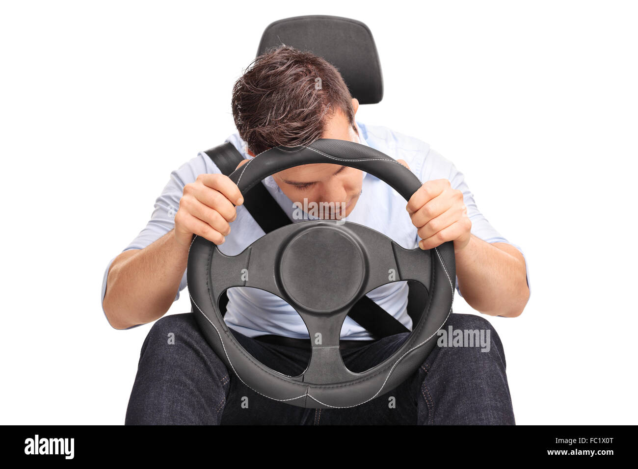 Studio shot of a young driver sleeping while driving isolated on white background Stock Photo