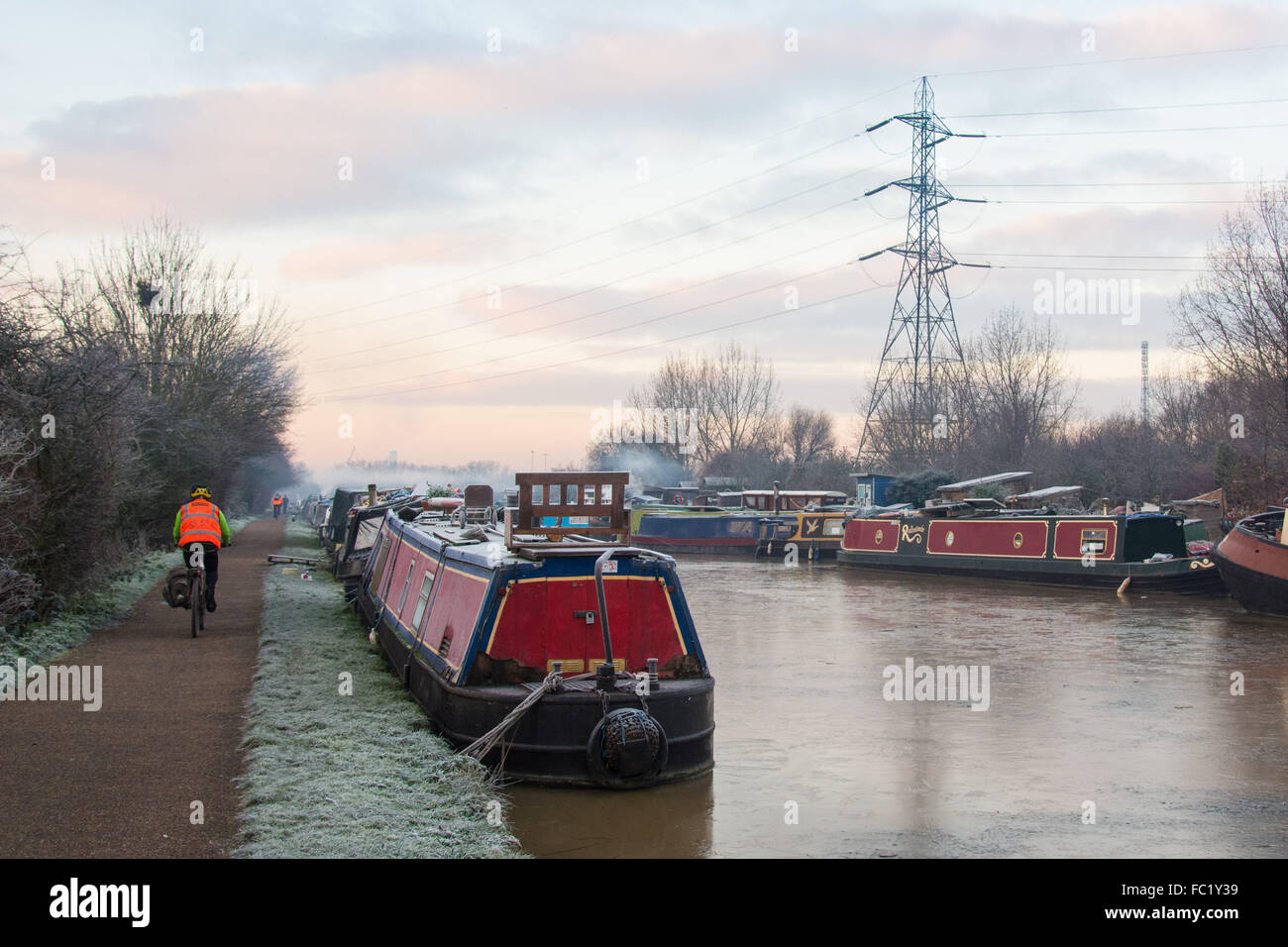 Tottenham Marshes, London UK, 20th January 2016. UK Weather. A bicycle commuter makes their way along the towpath as a second morning of sub-zero temperatures see the river Lee frozen. Credit: Patricia Phillips/Alamy Live News Stock Photo