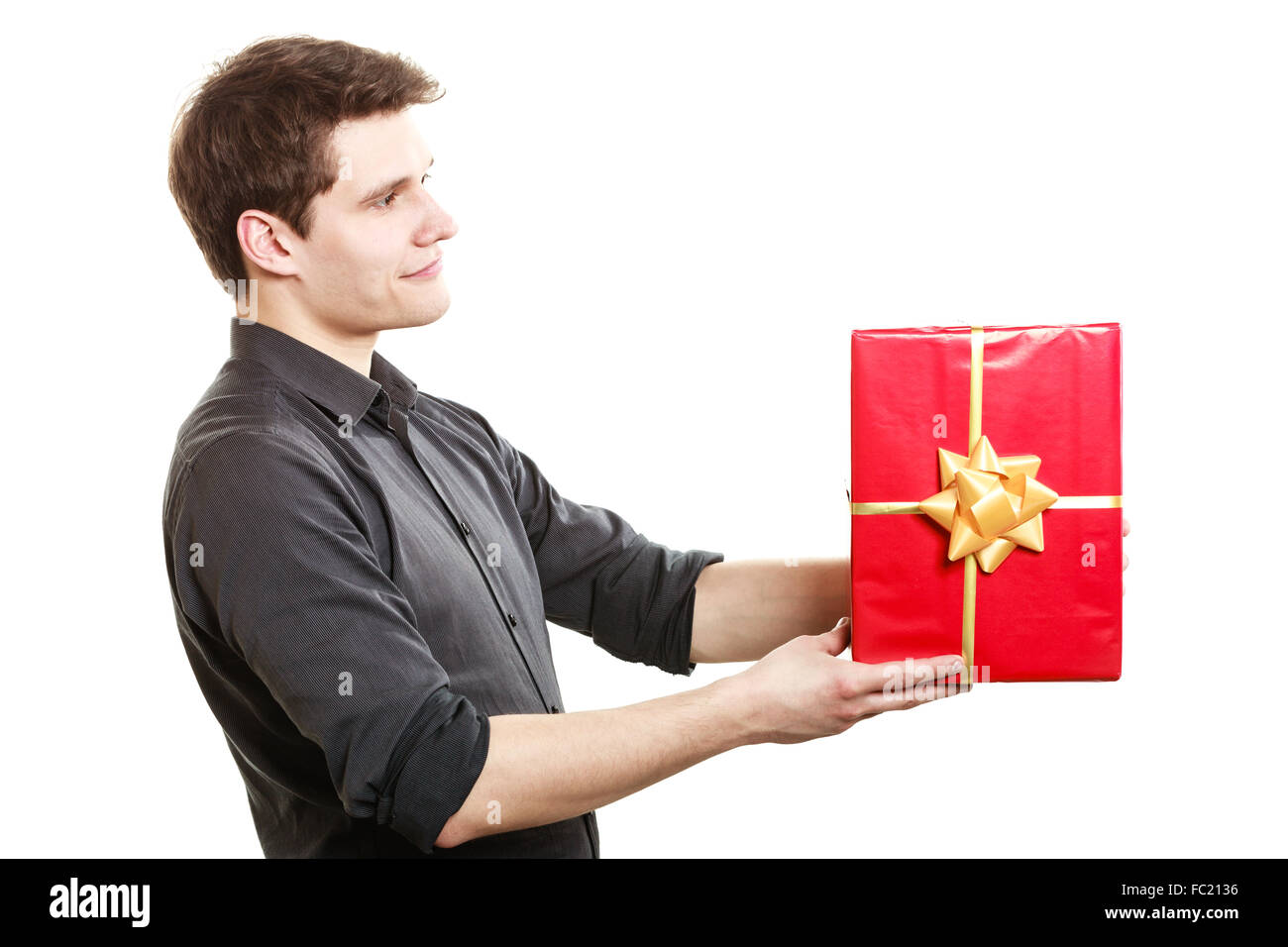 Holiday. Man giving red gift box with golden ribbon Stock Photo