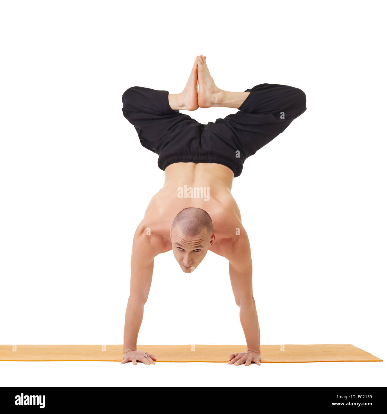 Yogi looking at camera while doing handstand Stock Photo