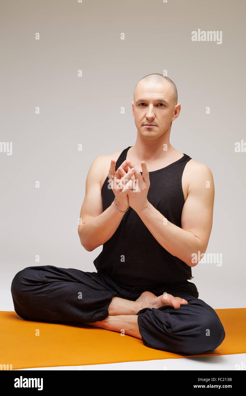 Yoga man posing at camera while exercising Stock Photo - Alamy