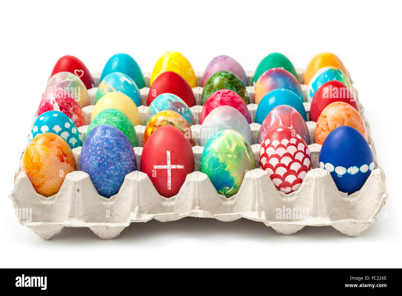 Full tray with colored and ornate Easter eggs isolated on white background. Stock Photo