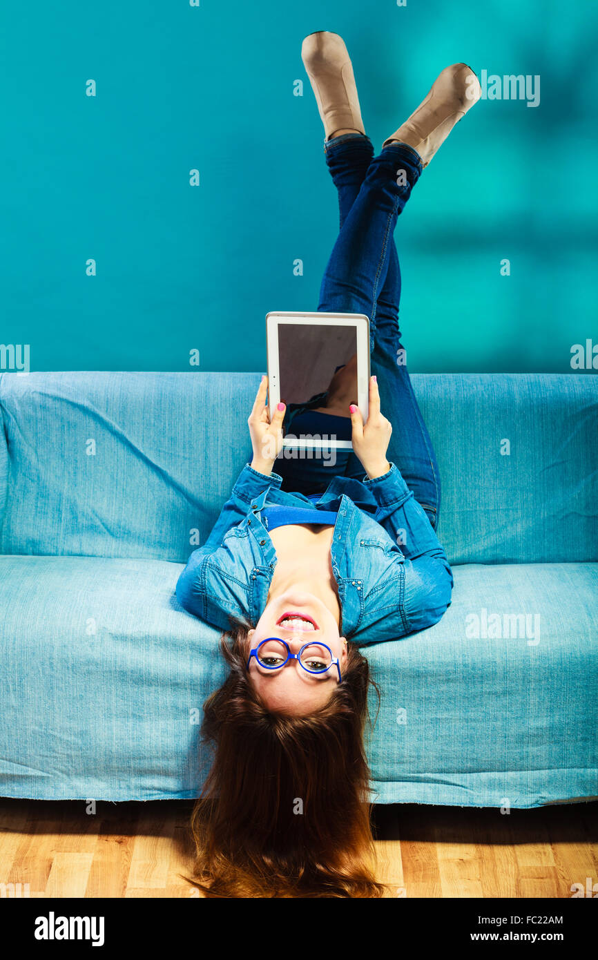 woman with tablet relaxing on couch blue color Stock Photo