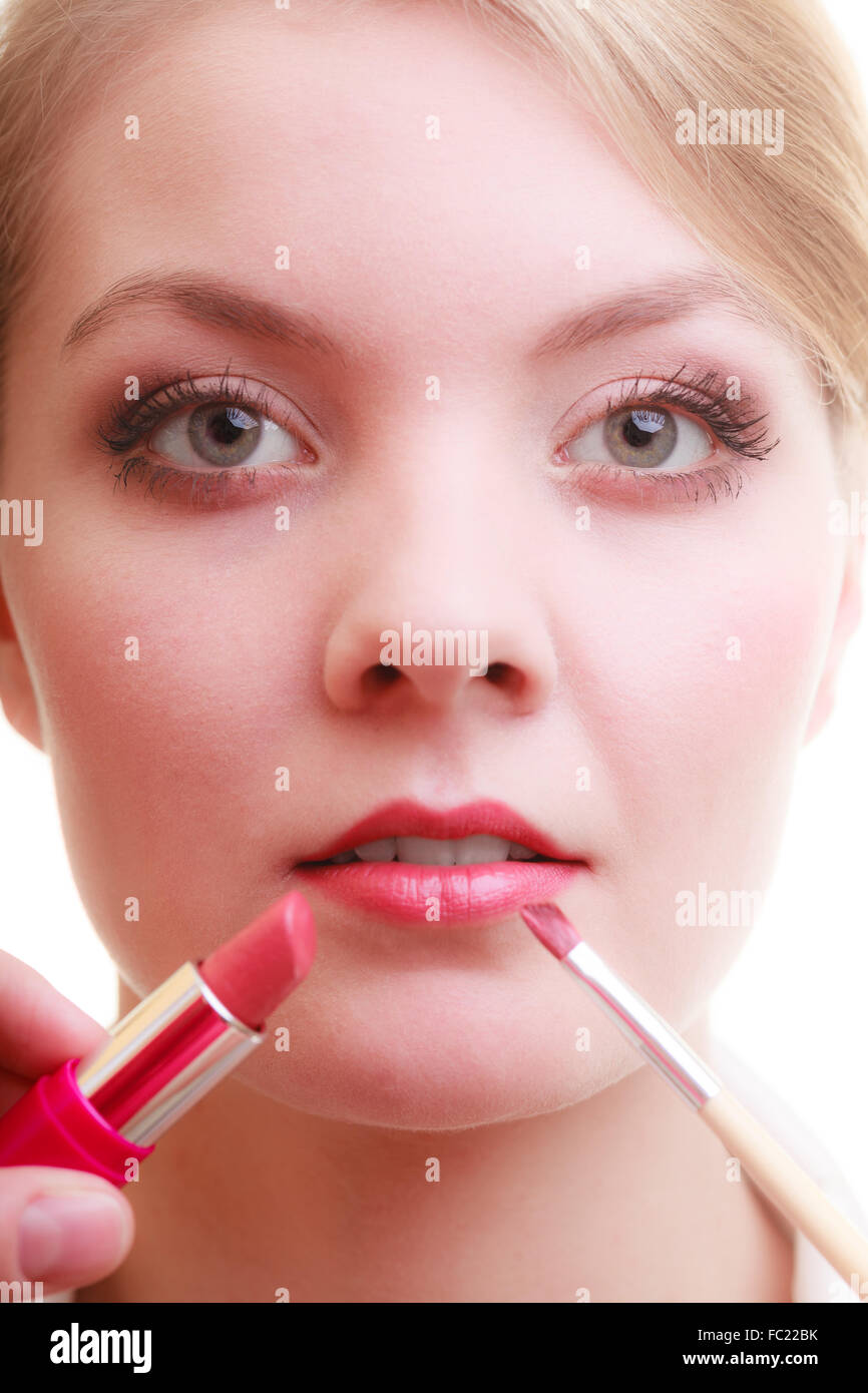 Part of face. Woman applying red lipstick with brush Stock Photo
