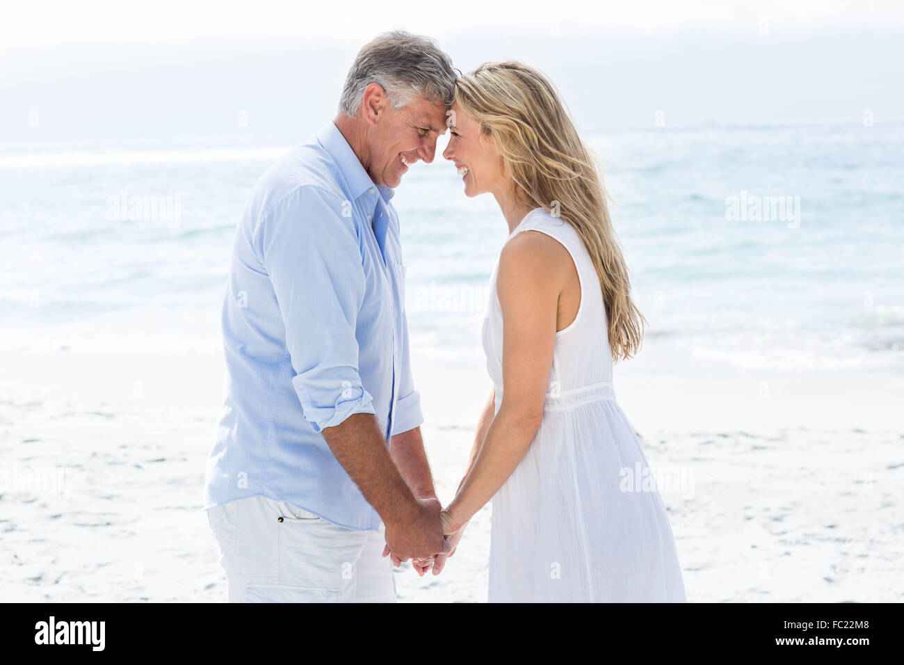 Happy couple holding hands and smiling at each other Stock Photo - Alamy