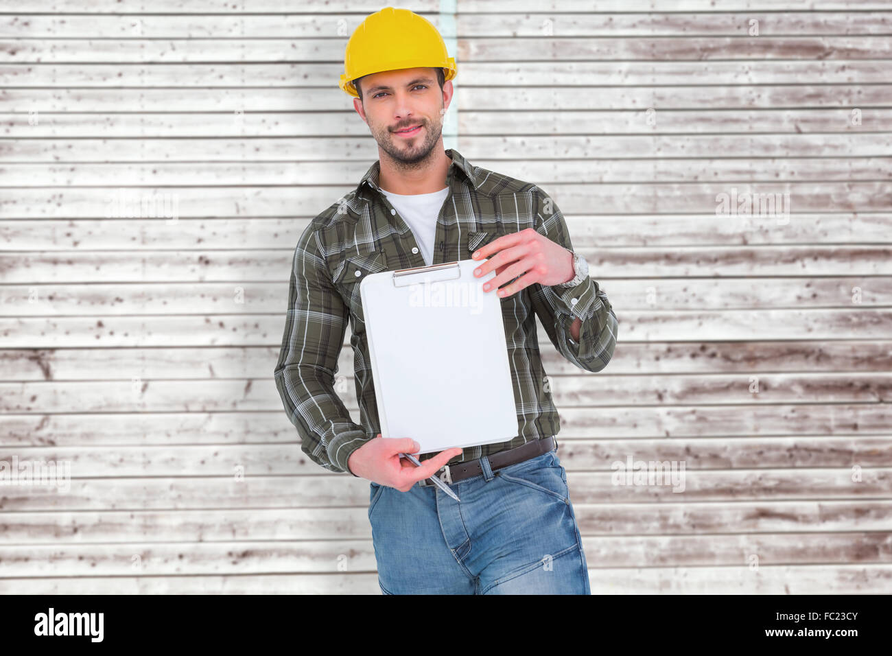 Composite image of smiling manual worker holding clipboard Stock Photo