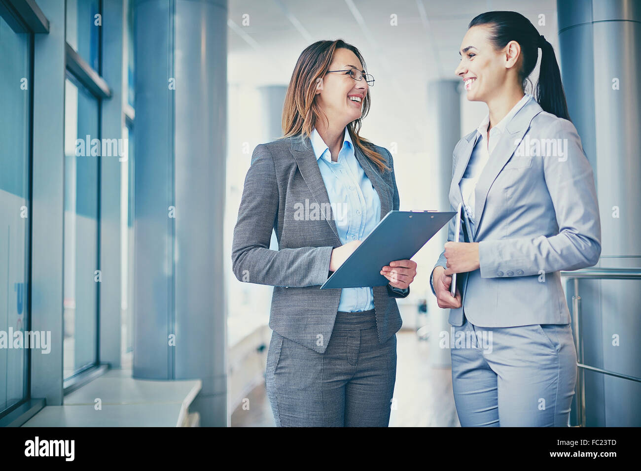 Two cheerful businesswomen discussing plans Stock Photo