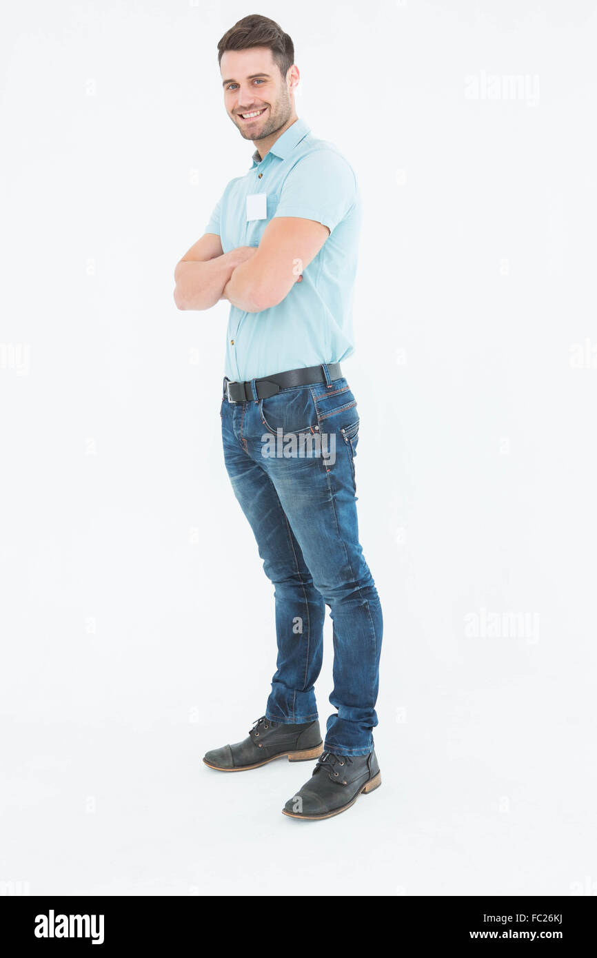 Smiling young delivery man standing arms crossed Stock Photo - Alamy