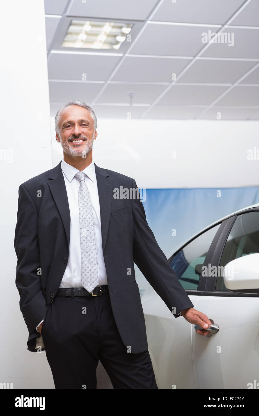 Smiling businessman holding a car door handles Stock Photo Alamy