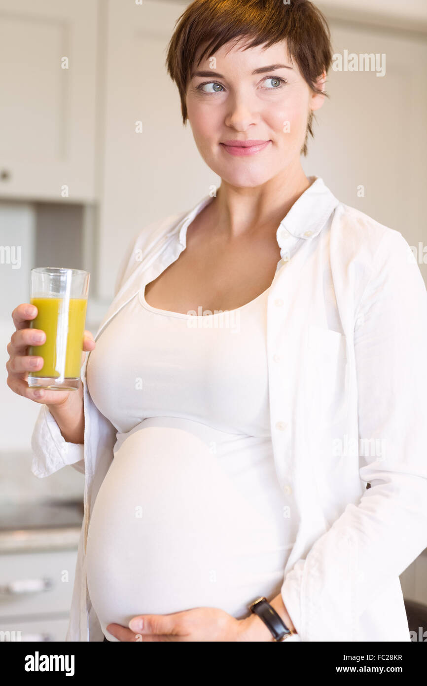 Pregnant woman having a glass of orange juice Stock Photo - Alamy