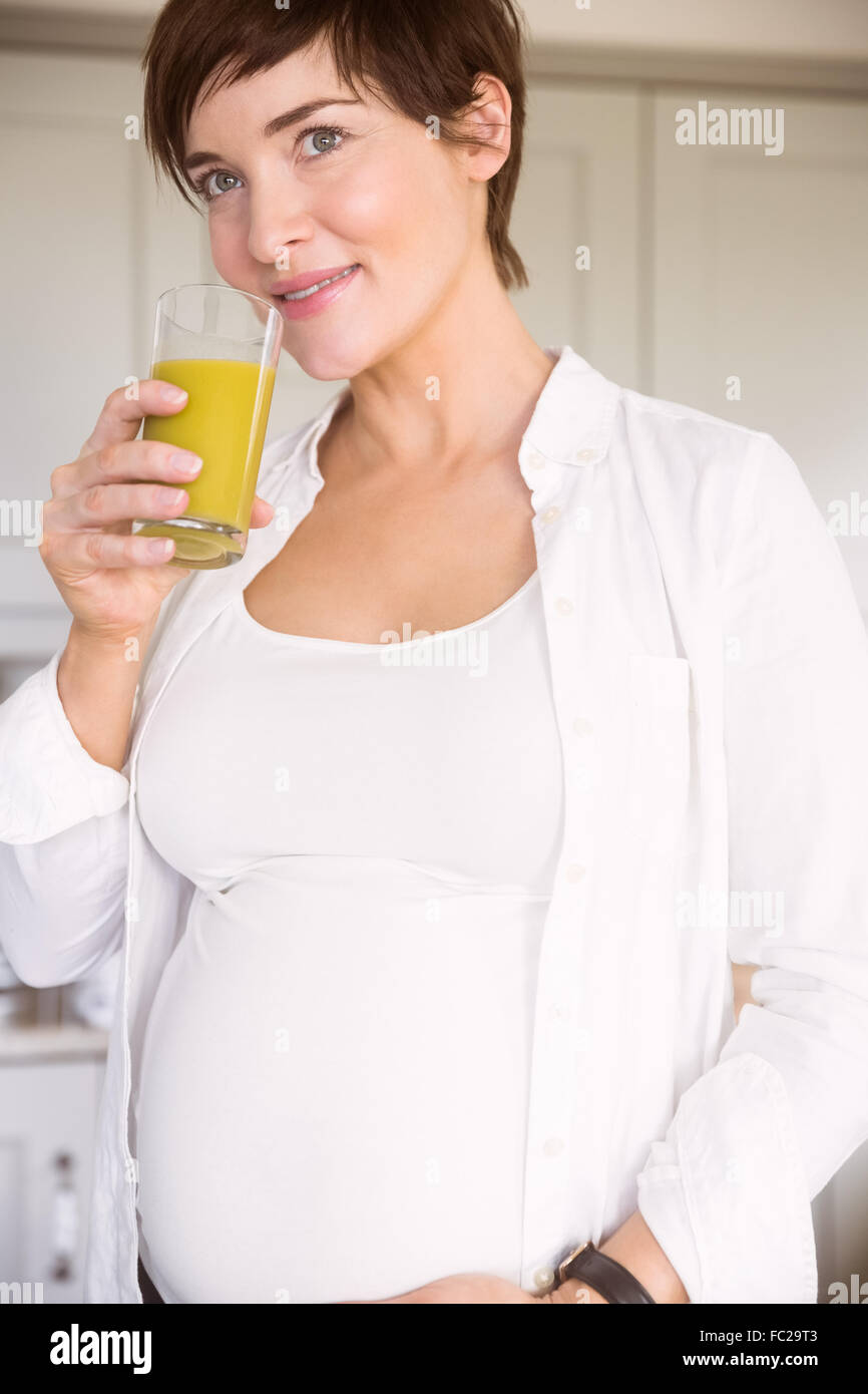 Pregnant woman drinking glass of orange juice Stock Photo - Alamy