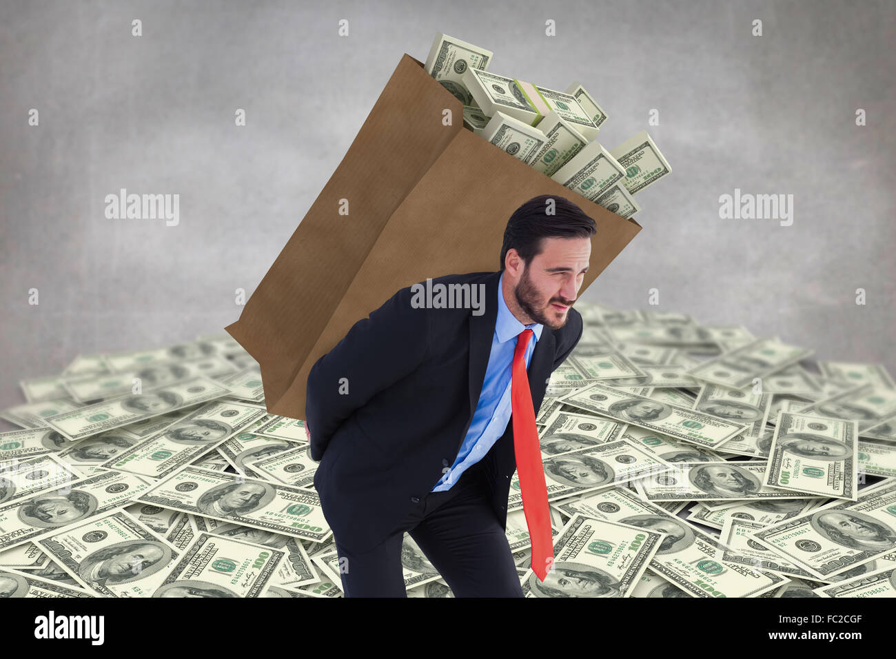 Composite image of businessman carrying bag of dollars Stock Photo - Alamy