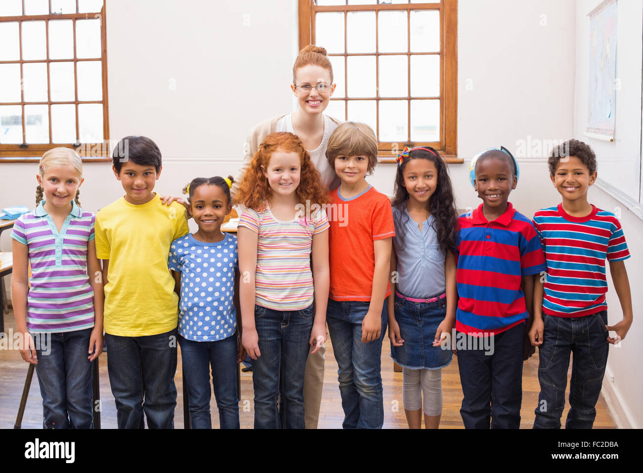 Teacher and pupils smiling at camera in classroom Stock Photo - Alamy