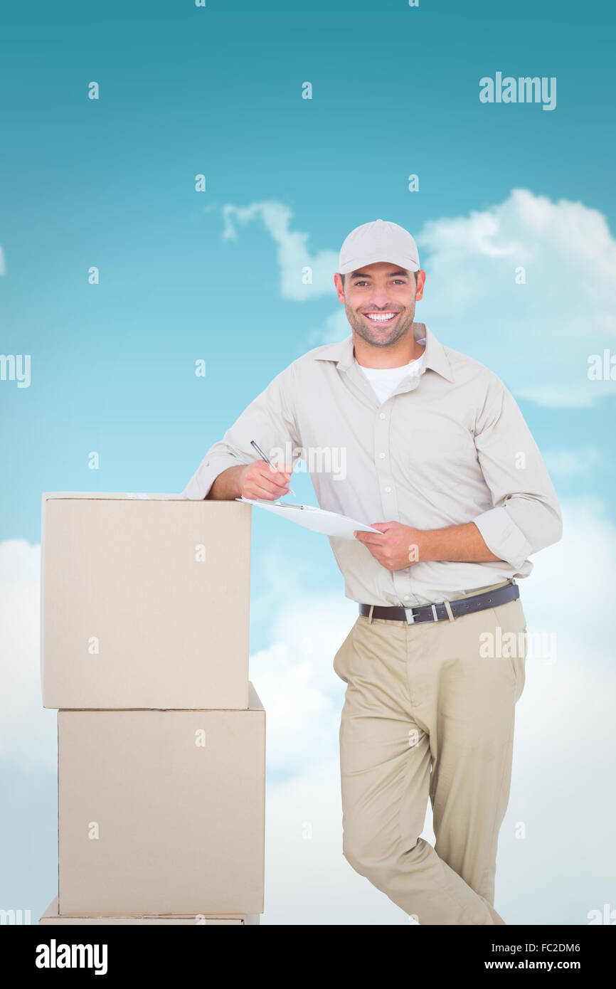 Composite image of delivery man with clipboard leaning on cardboard boxes Stock Photo
