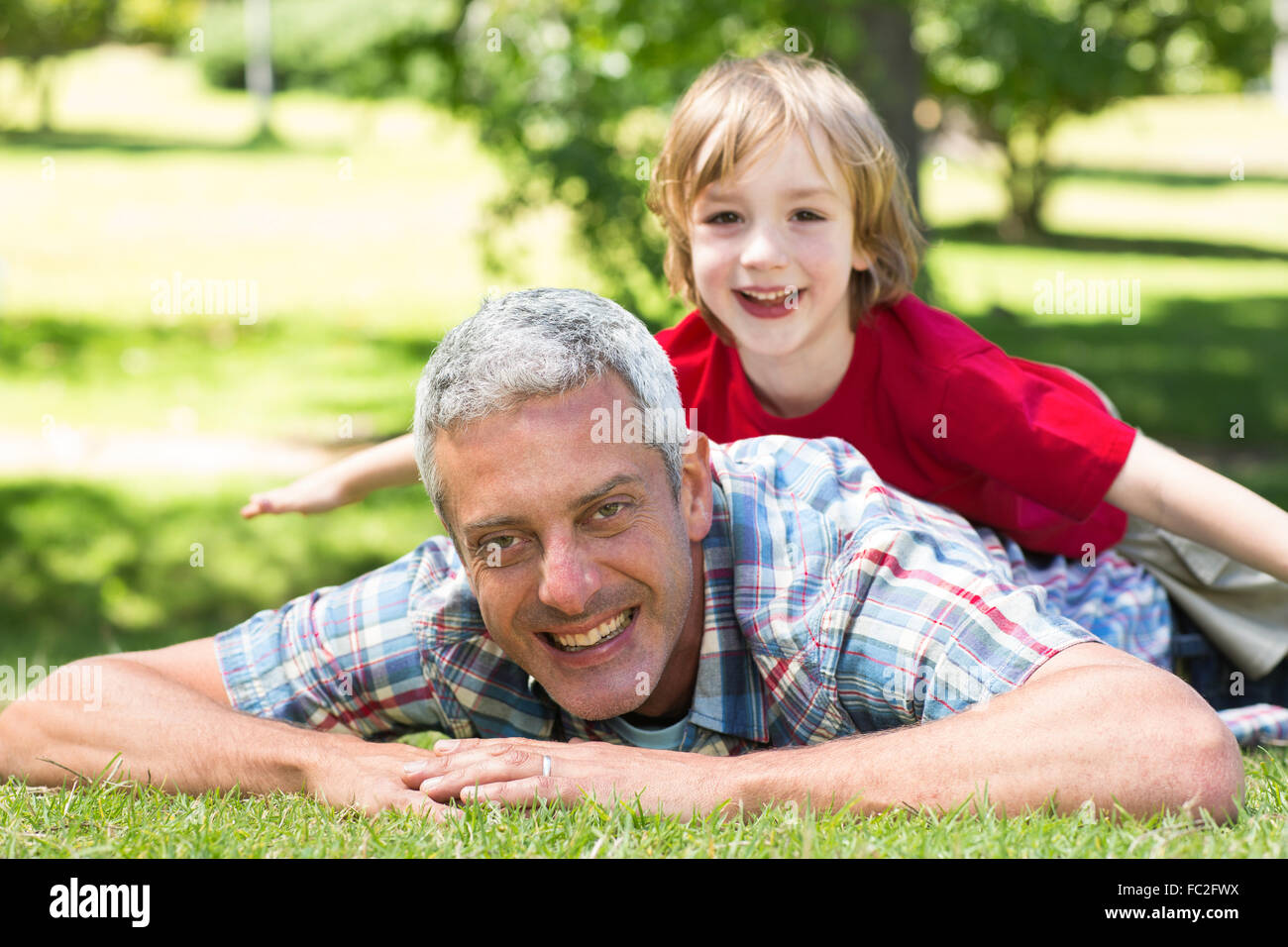Happy father lying on the grass with his son Stock Photo - Alamy