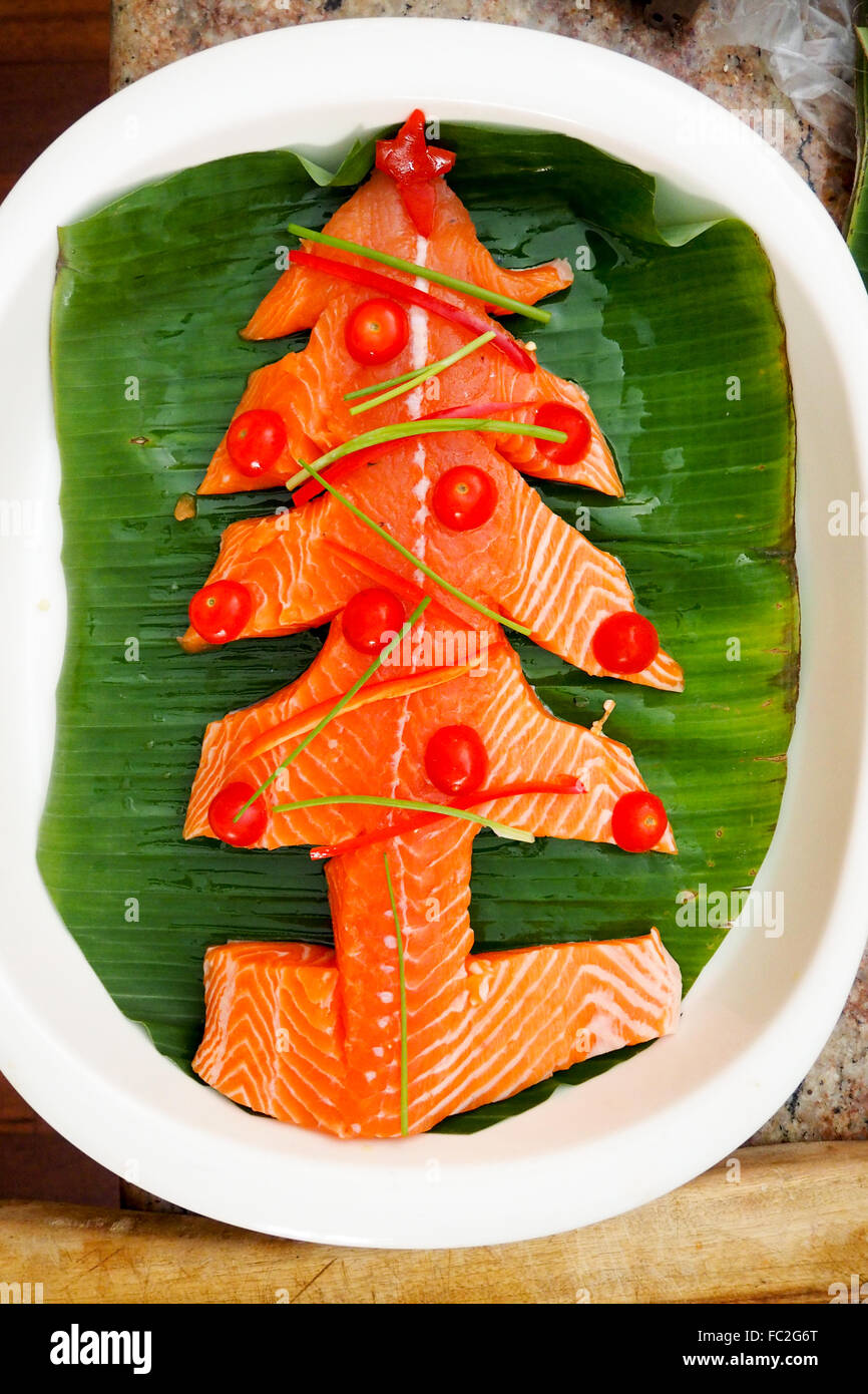 Salmon fillet cut to resemble a Christmas tree in preparation for a Christmas lunch. Stock Photo