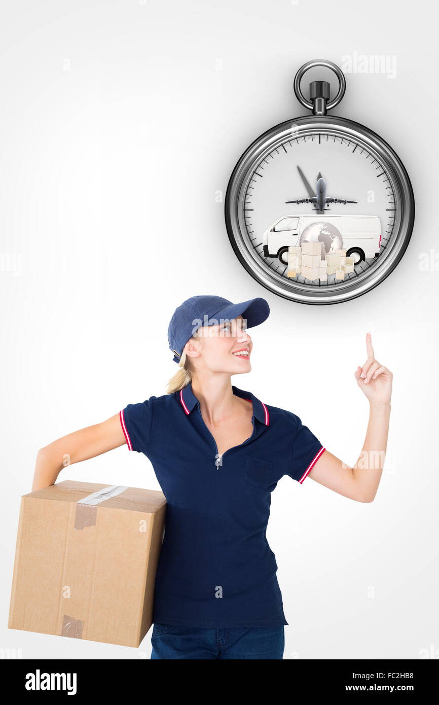 Composite image of happy delivery woman holding cardboard box and pointing up Stock Photo