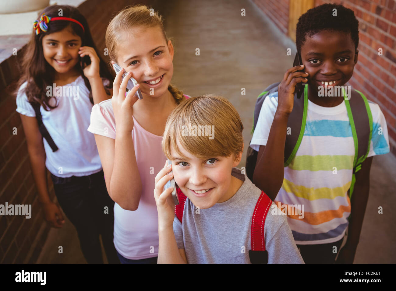 School kids using cellphones in school corridor Stock Photo Alamy