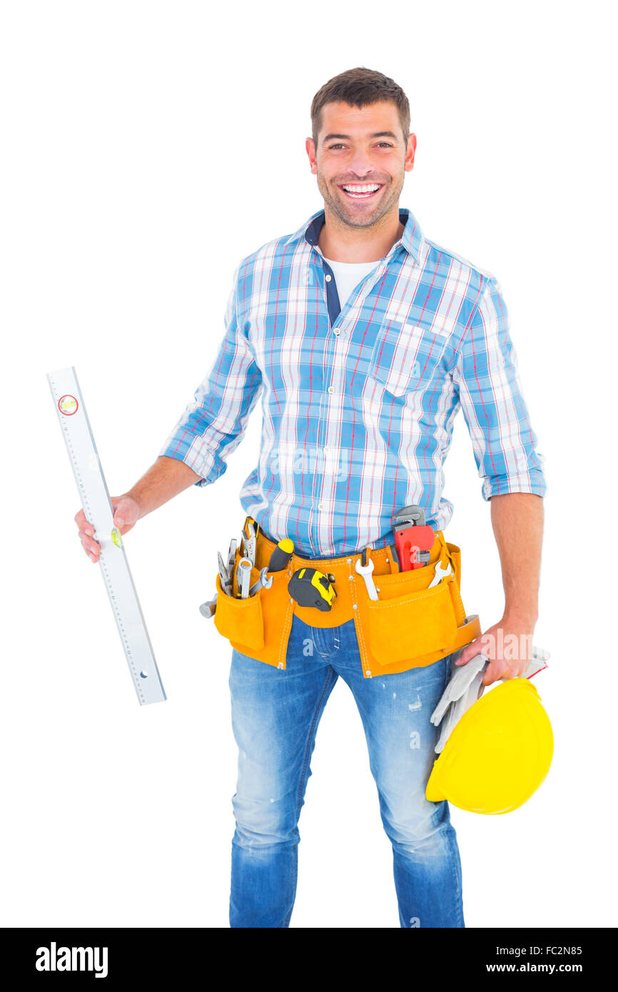 Portrait of smiling manual worker holding spirit level Stock Photo