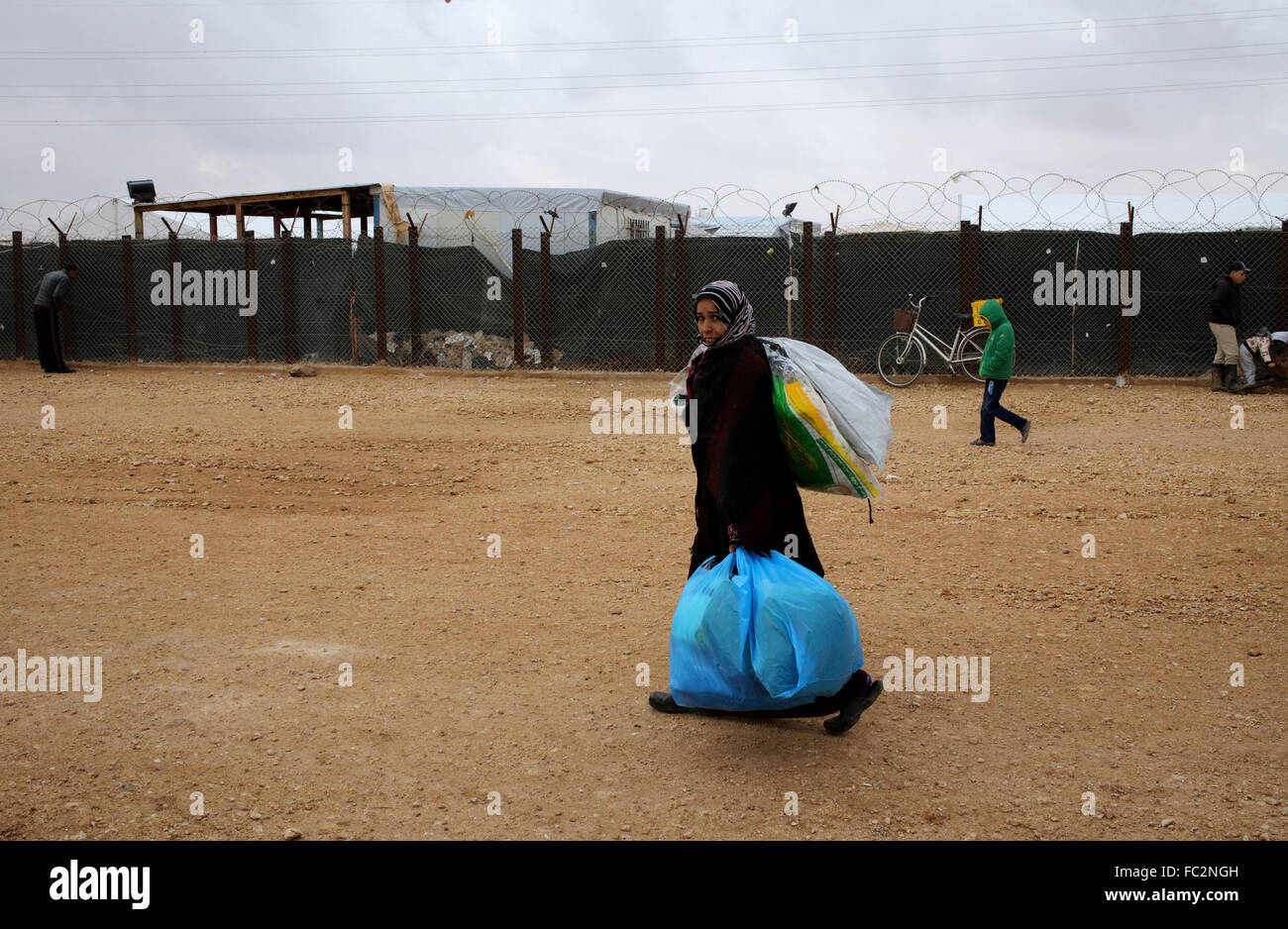 (160120) -- MAFRAQ, Jan. 20, 2016 (Xinhua) -- A Syrian refugee woman takes aid packages at Al Zaatari refugee camp in the Jordanian city of Mafraq, near the border with Syria, Jan. 20, 2016. (Xinhua/Mohammad Abu Ghosh) Stock Photo