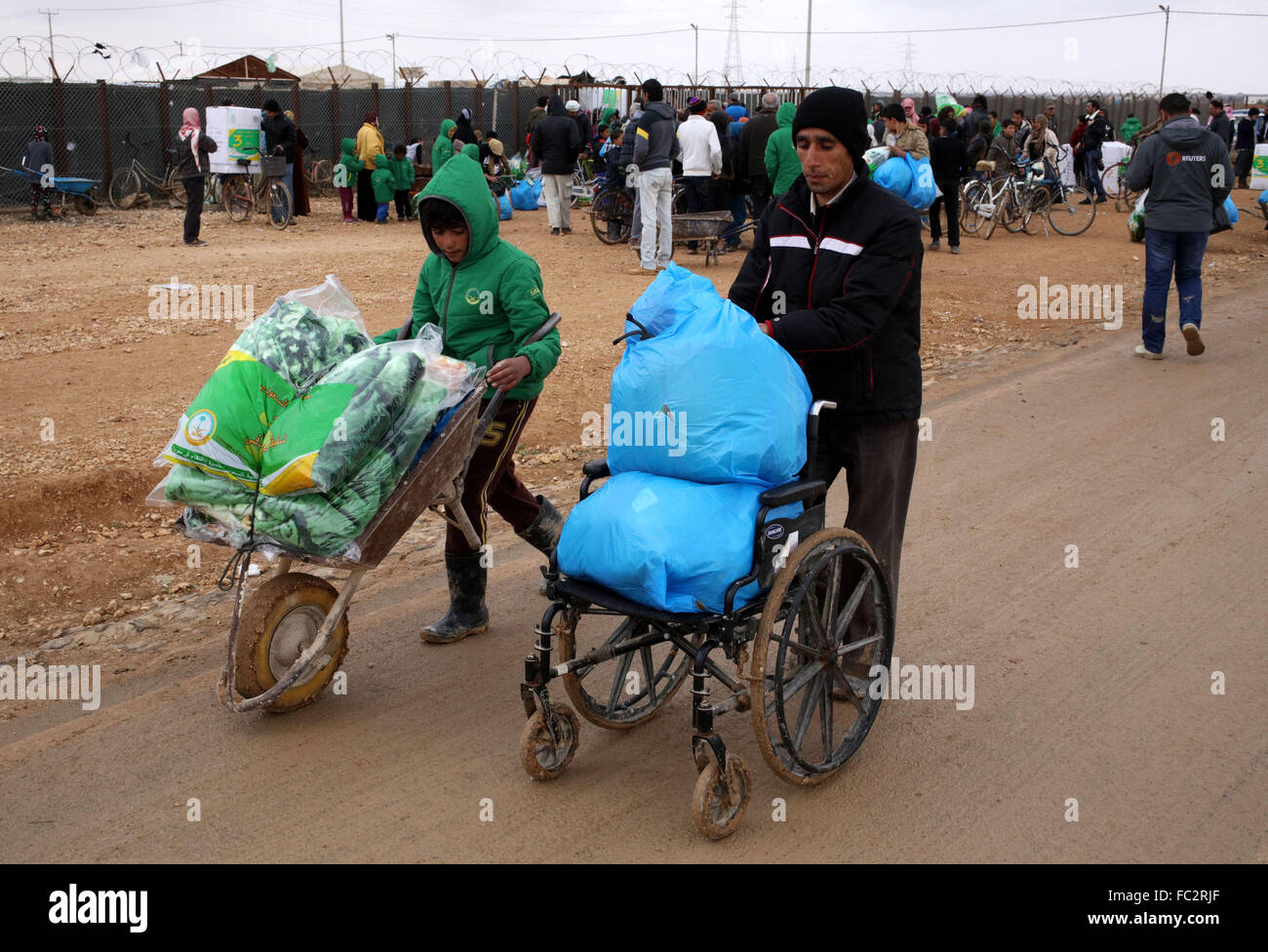 (160120) -- MAFRAQ, Jan. 20, 2016 (Xinhua) -- Syrian refugees take aid packages at Al Zaatari refugee camp in the Jordanian city of Mafraq, near the border with Syria, Jan. 20, 2016. (Xinhua/Mohammad Abu Ghosh) Stock Photo