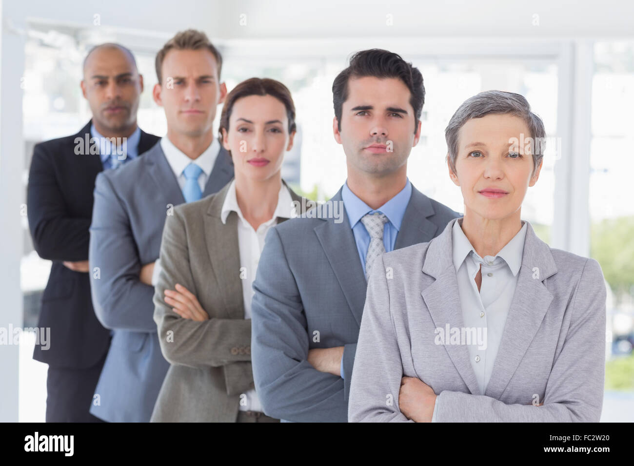 Business people standing in a row arms crossed Stock Photo - Alamy