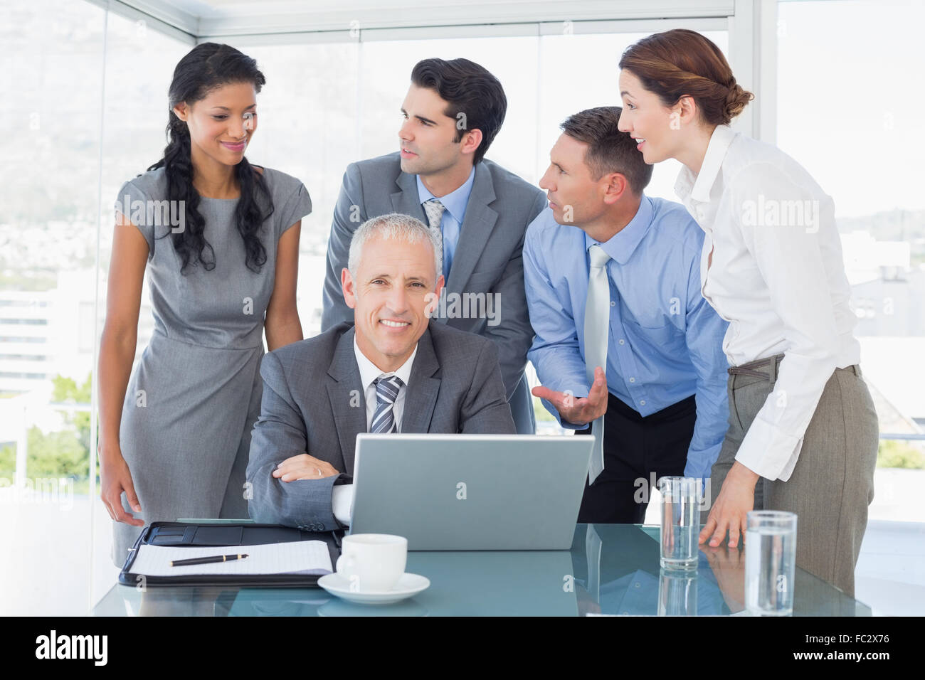 Business team working happily together on laptop Stock Photo - Alamy