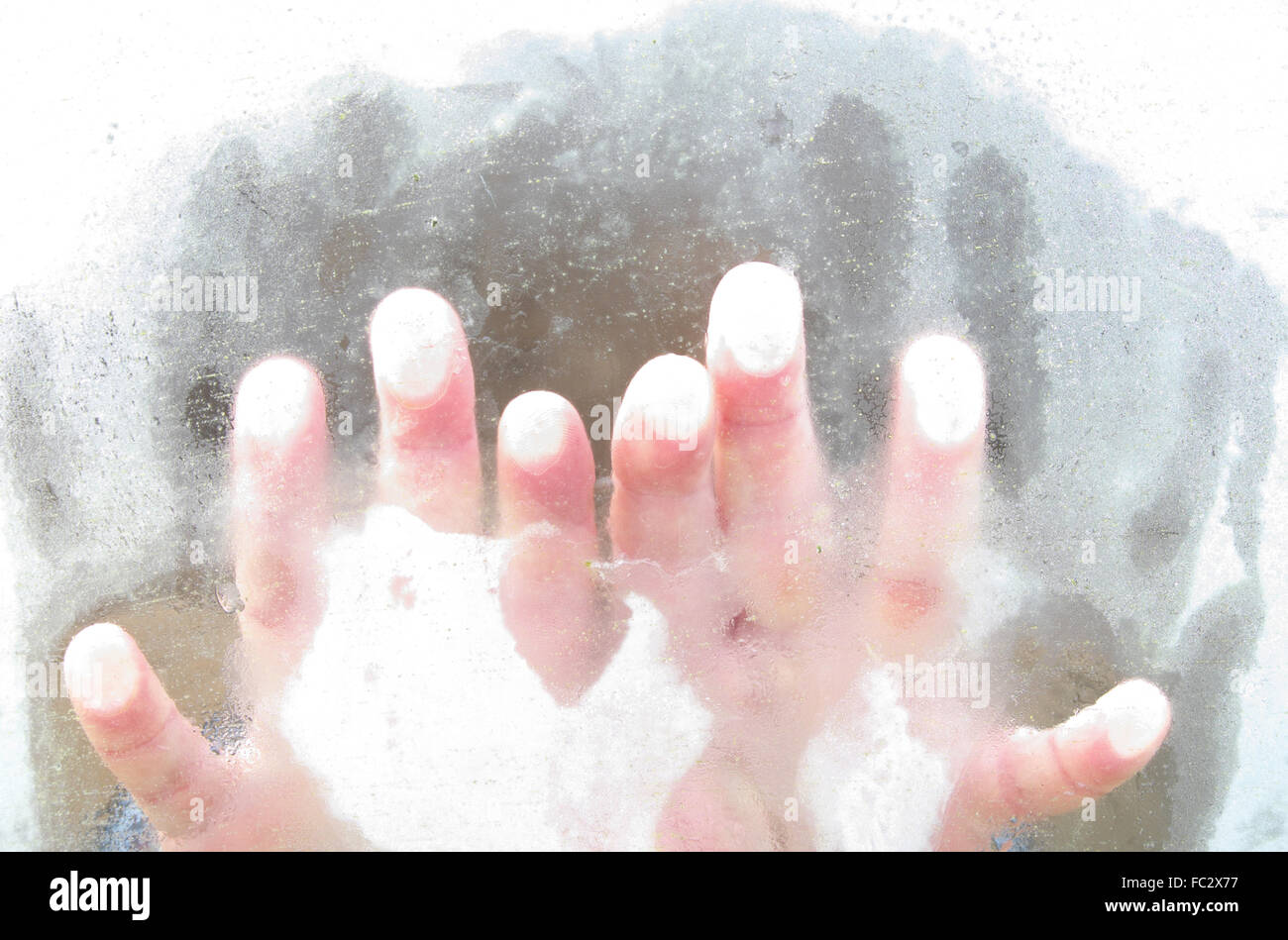 Frozen cold fingers fingertips on icy window in winter Stock Photo