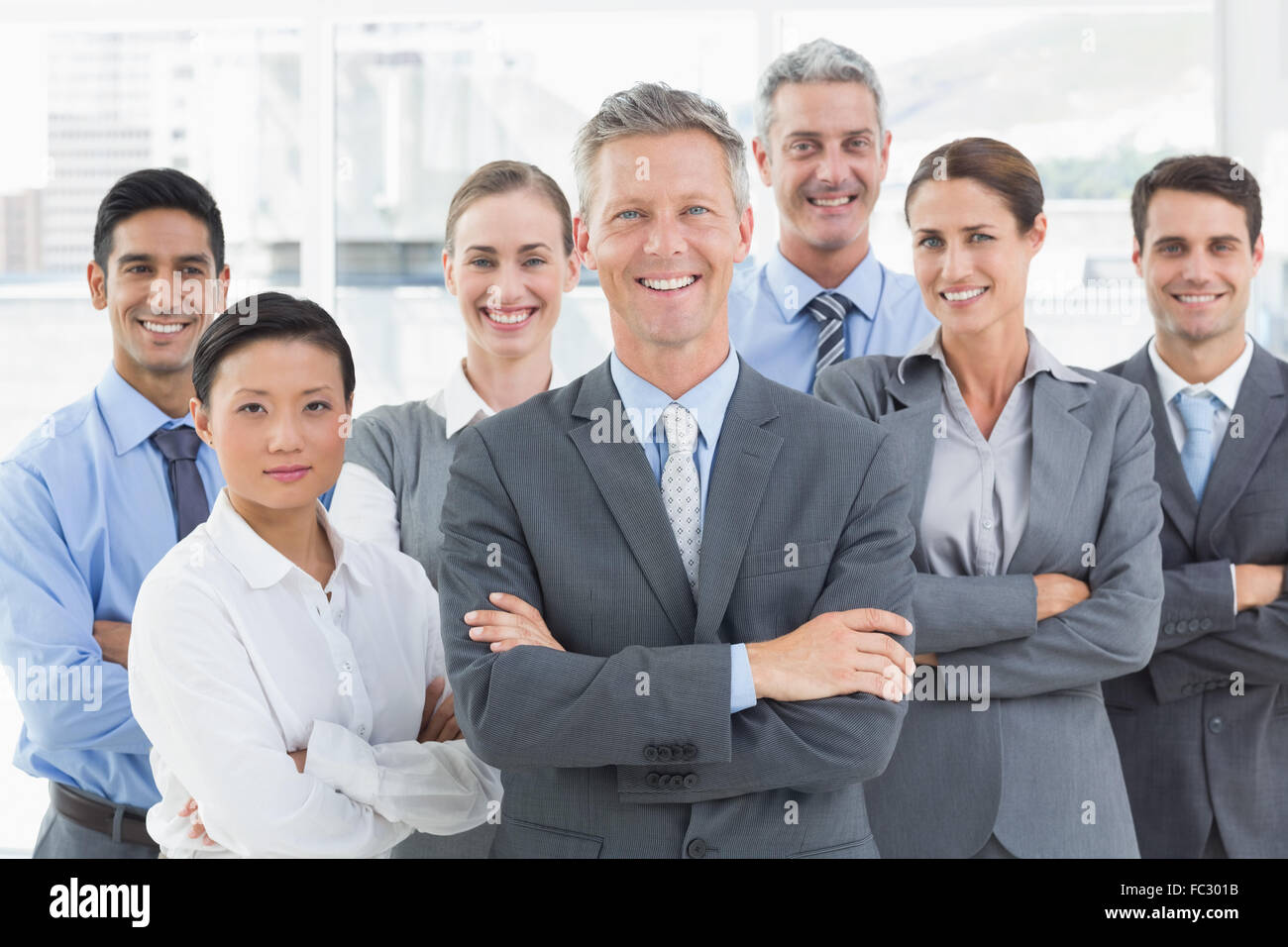 Happy business people looking at camera with arms crossed Stock Photo ...
