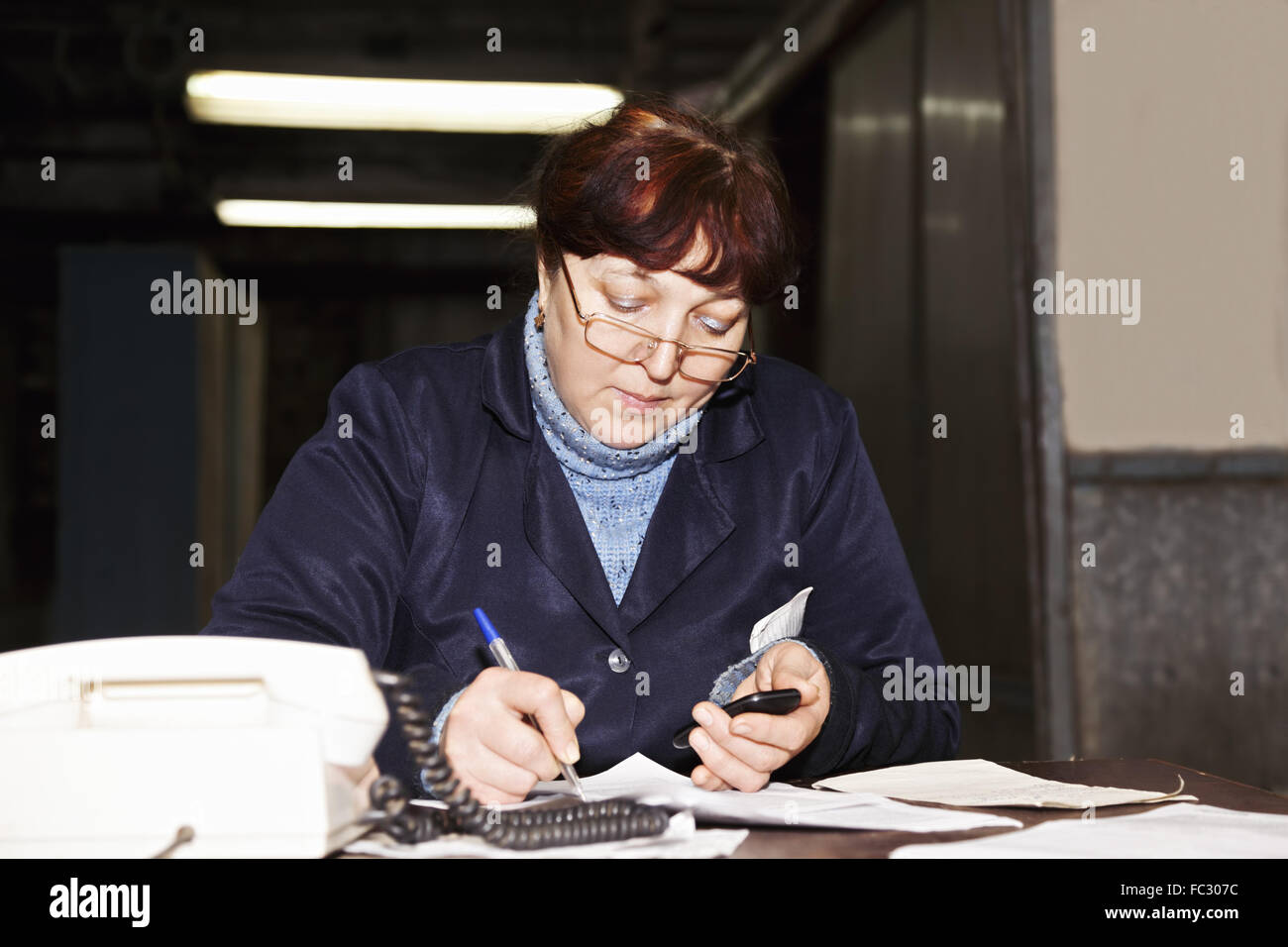 Forewoman writing at the desk Stock Photo