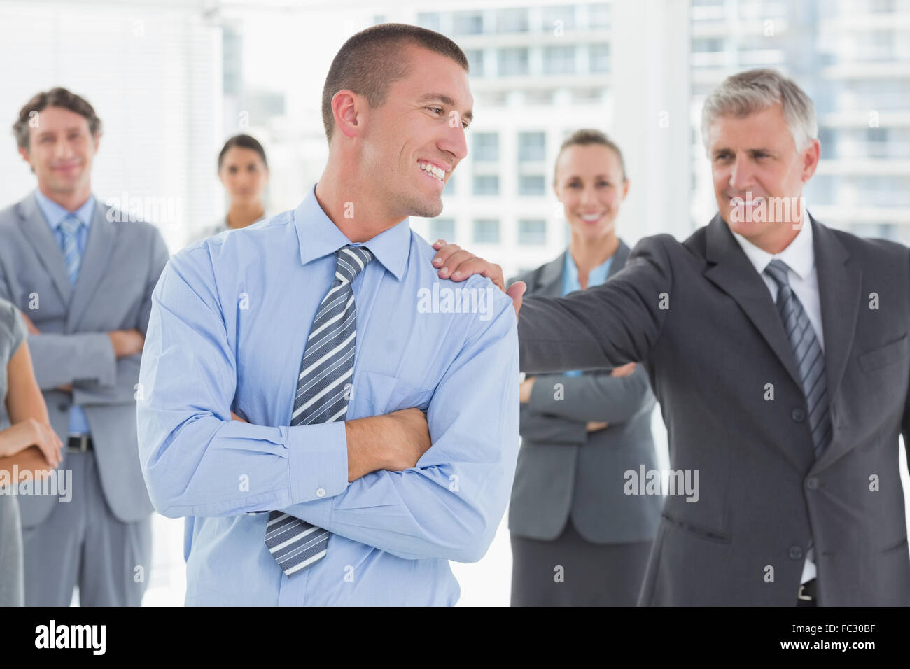 Smiling business team standing with arms crossed Stock Photo - Alamy