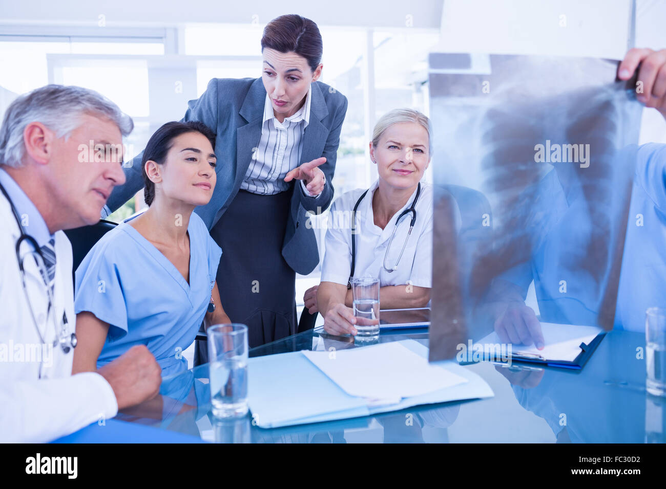 Team of doctors and businesswoman examining xray Stock Photo - Alamy