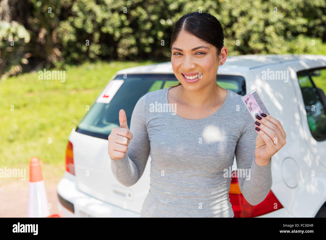 excited young woman showing a driving license she just got Stock Photo