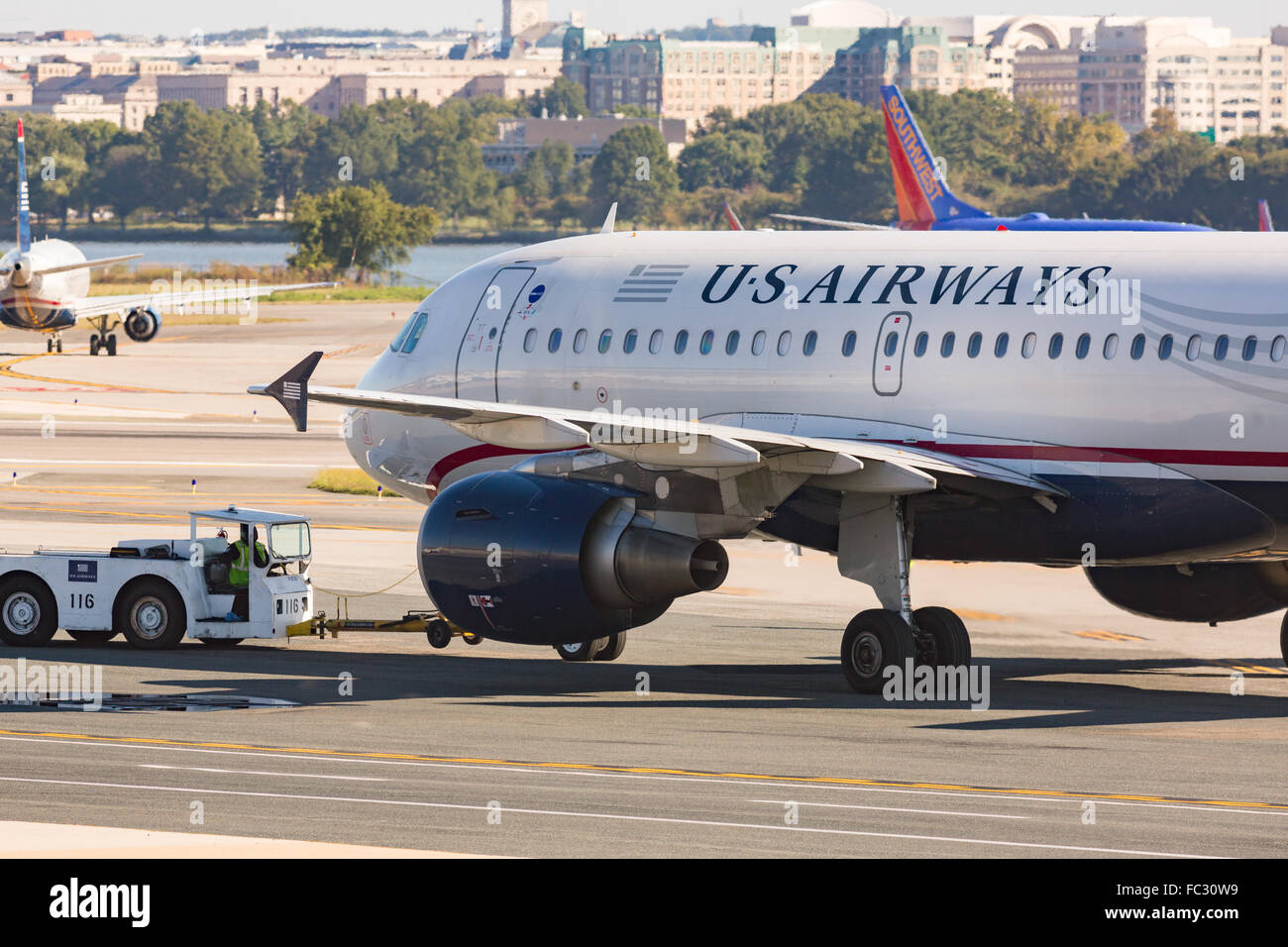 A U.S. Airways aircraft is towed to the gate at Reagan National Airport across the Potomac from Washington during operations October 5, 2014 in Arlington, Virginia. Stock Photo