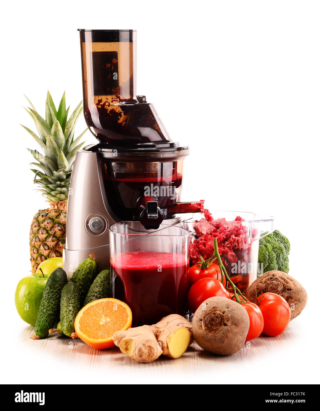 Slow juicer with organic fruits and vegetables isolated on white. Detox