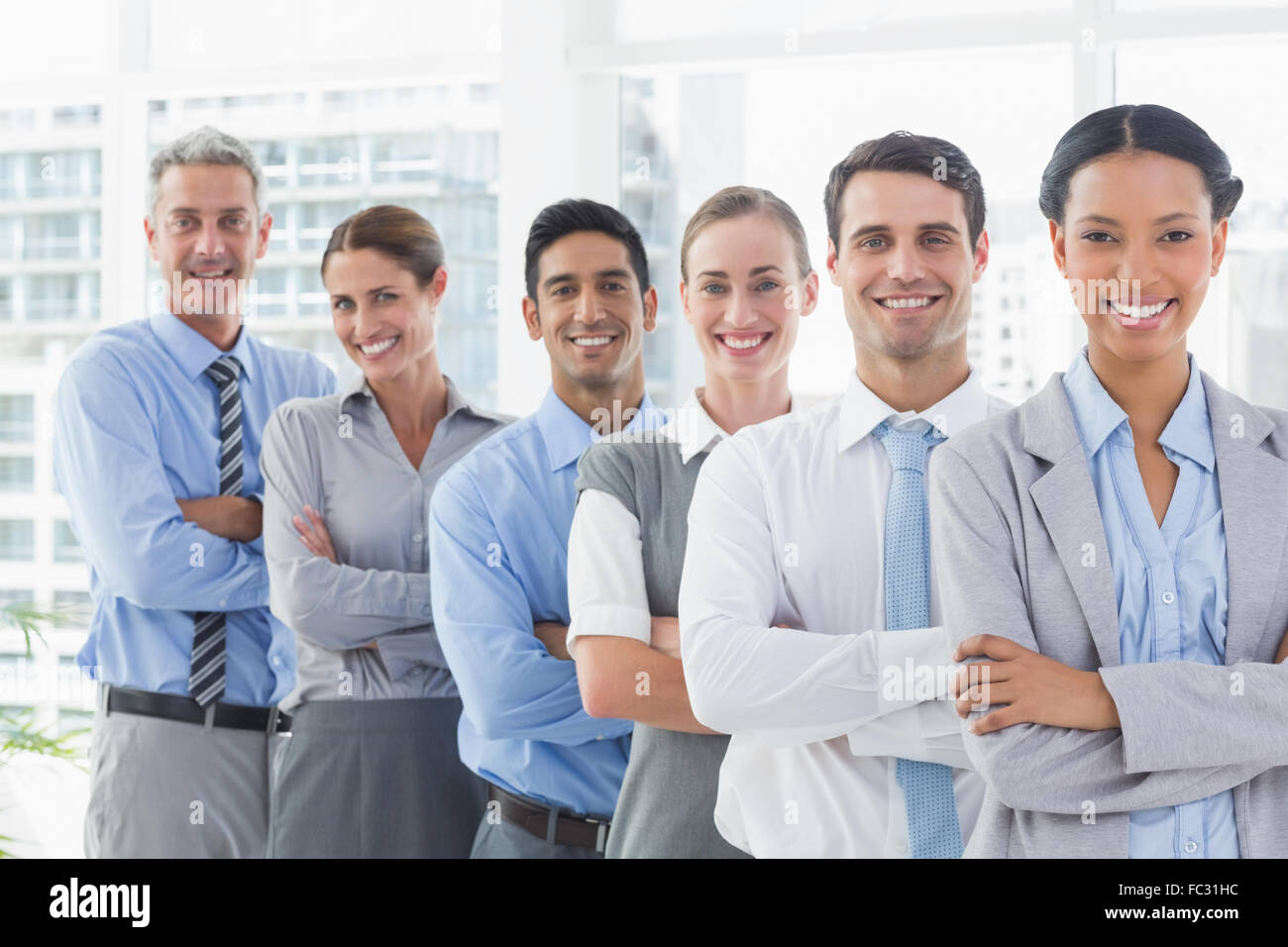 Happy business people looking at camera in a row Stock Photo - Alamy