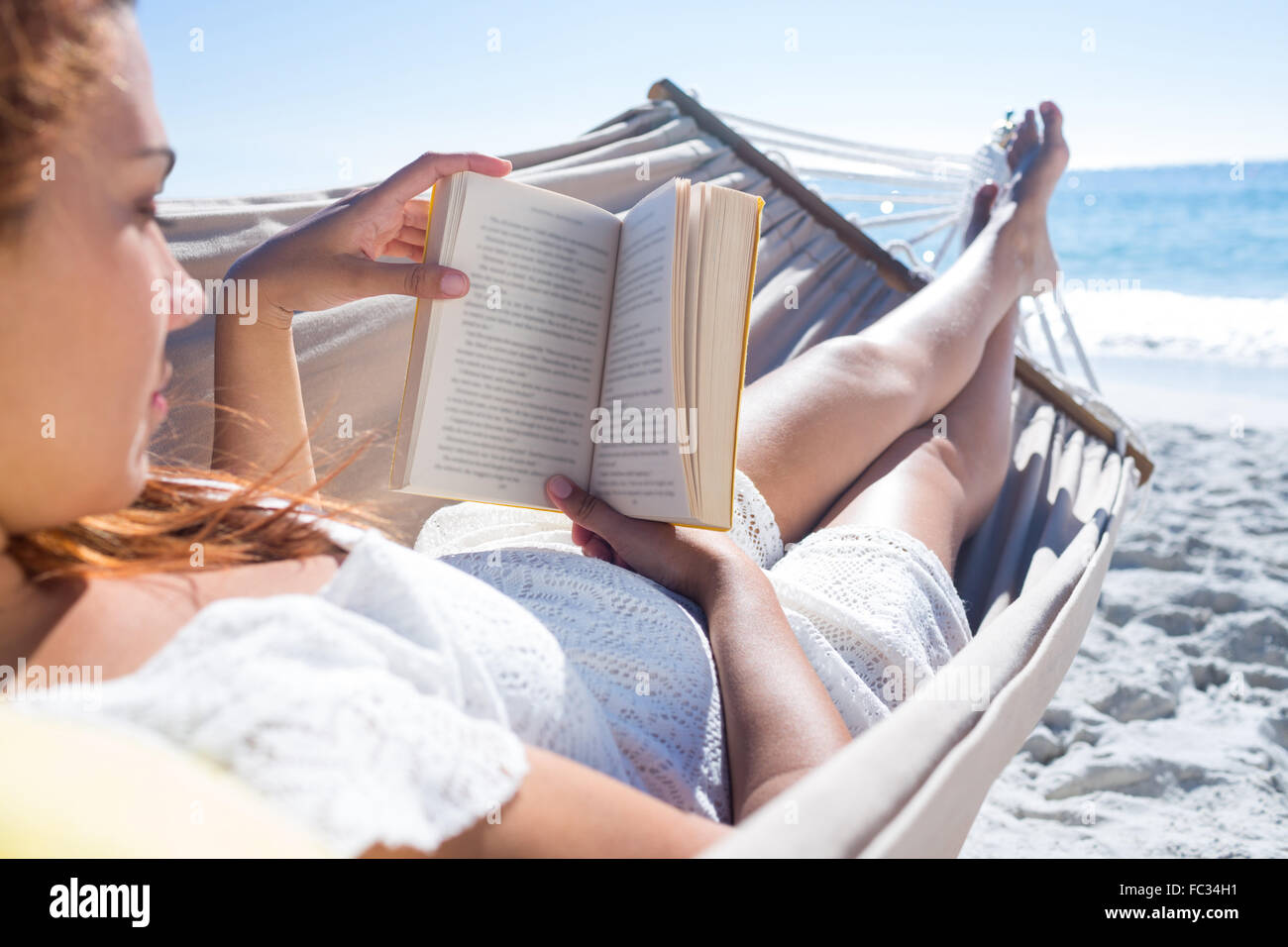 Brunette reading a book while relaxing in the hammock Stock Photo - Alamy