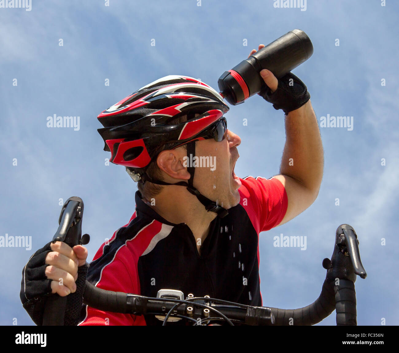 bicyclist cools his head while cycling on a bicycle Stock Photo