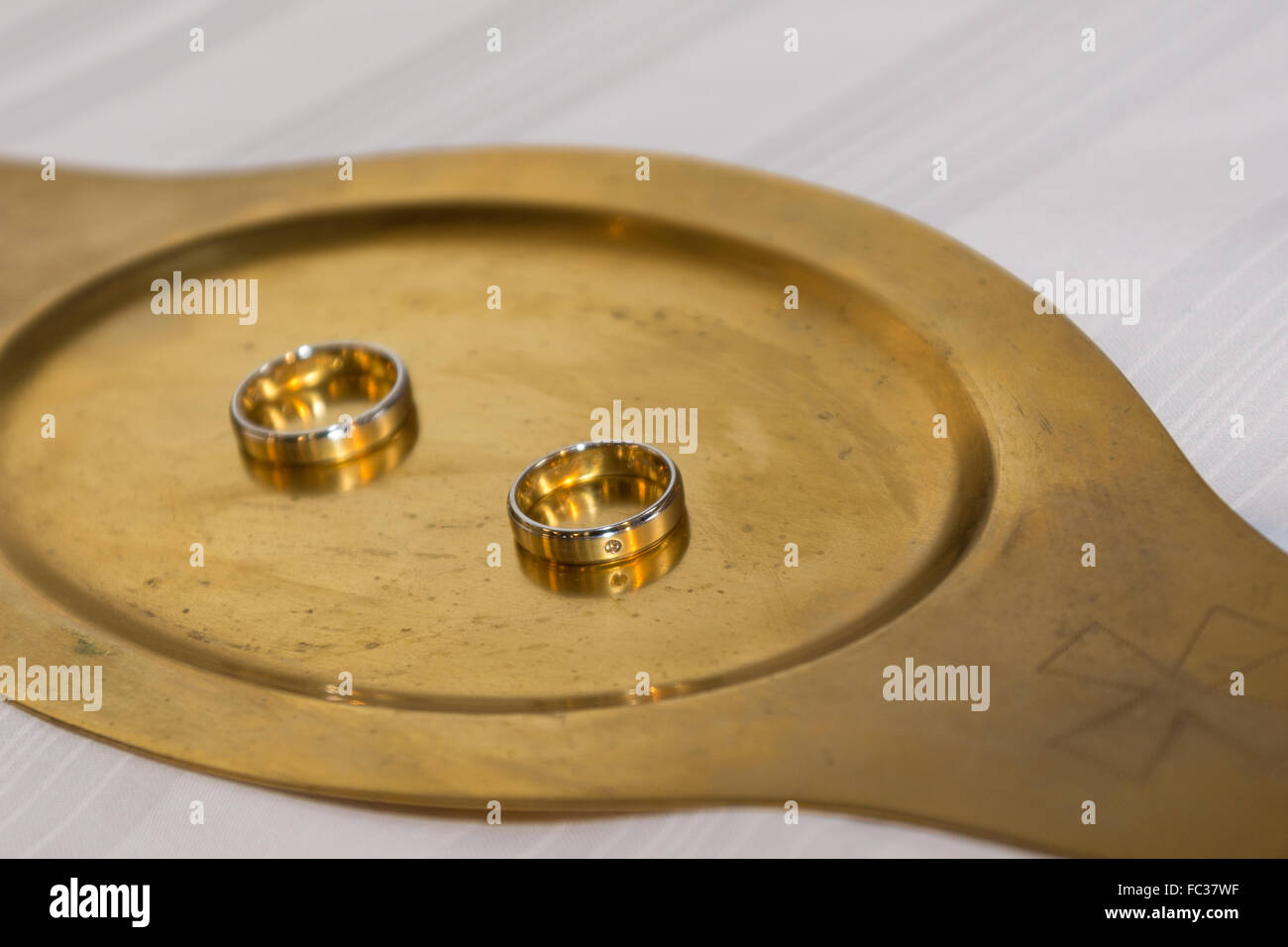 Two gold wedding rings on a gold tablet Stock Photo