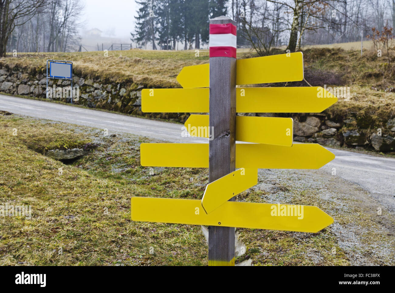 wooden pole with yellow unlabeled signposts Stock Photo