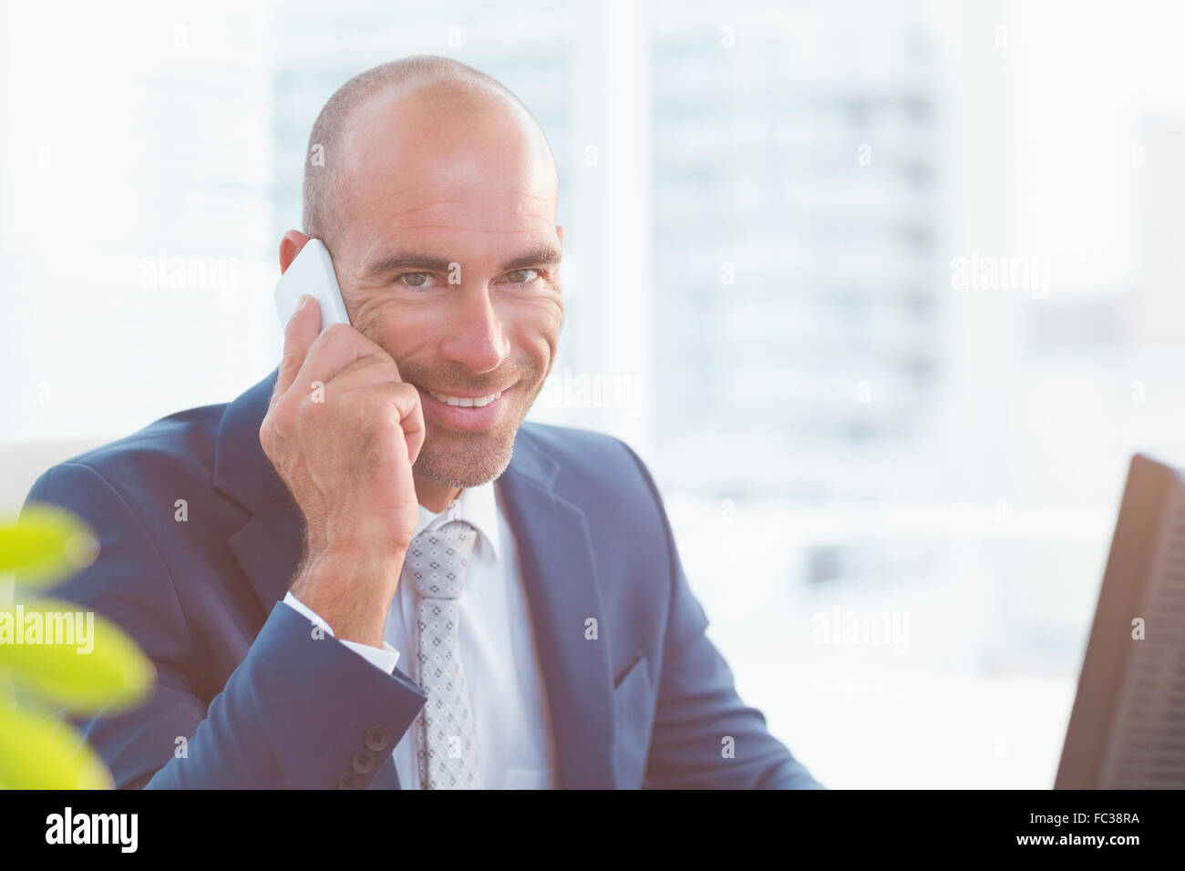 Smiling businessman looking at camera and calling Stock Photo - Alamy