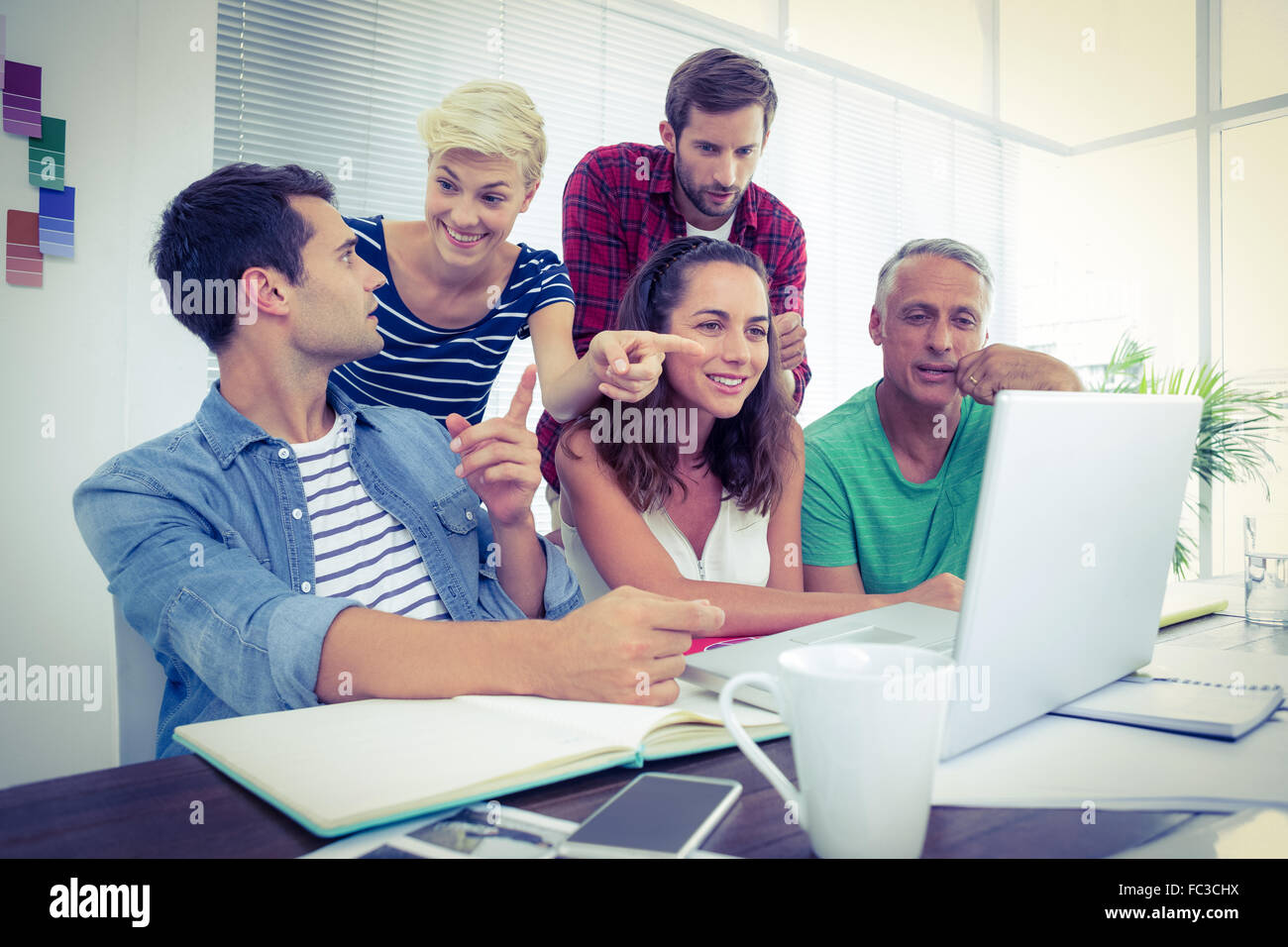 Creative business team using laptop in meeting Stock Photo - Alamy